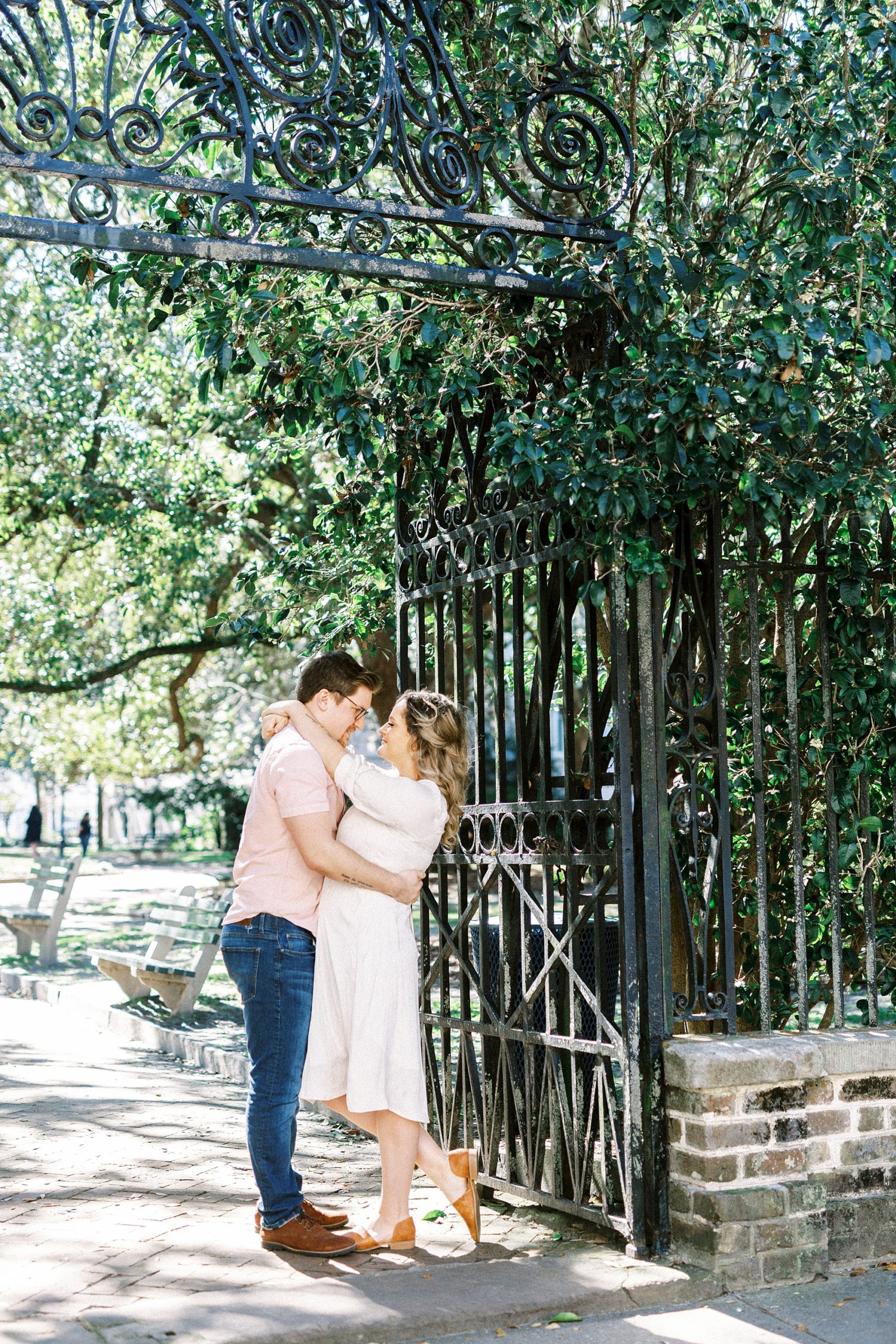 bride and groom hug by gate during downtown Charleston anniversary photos