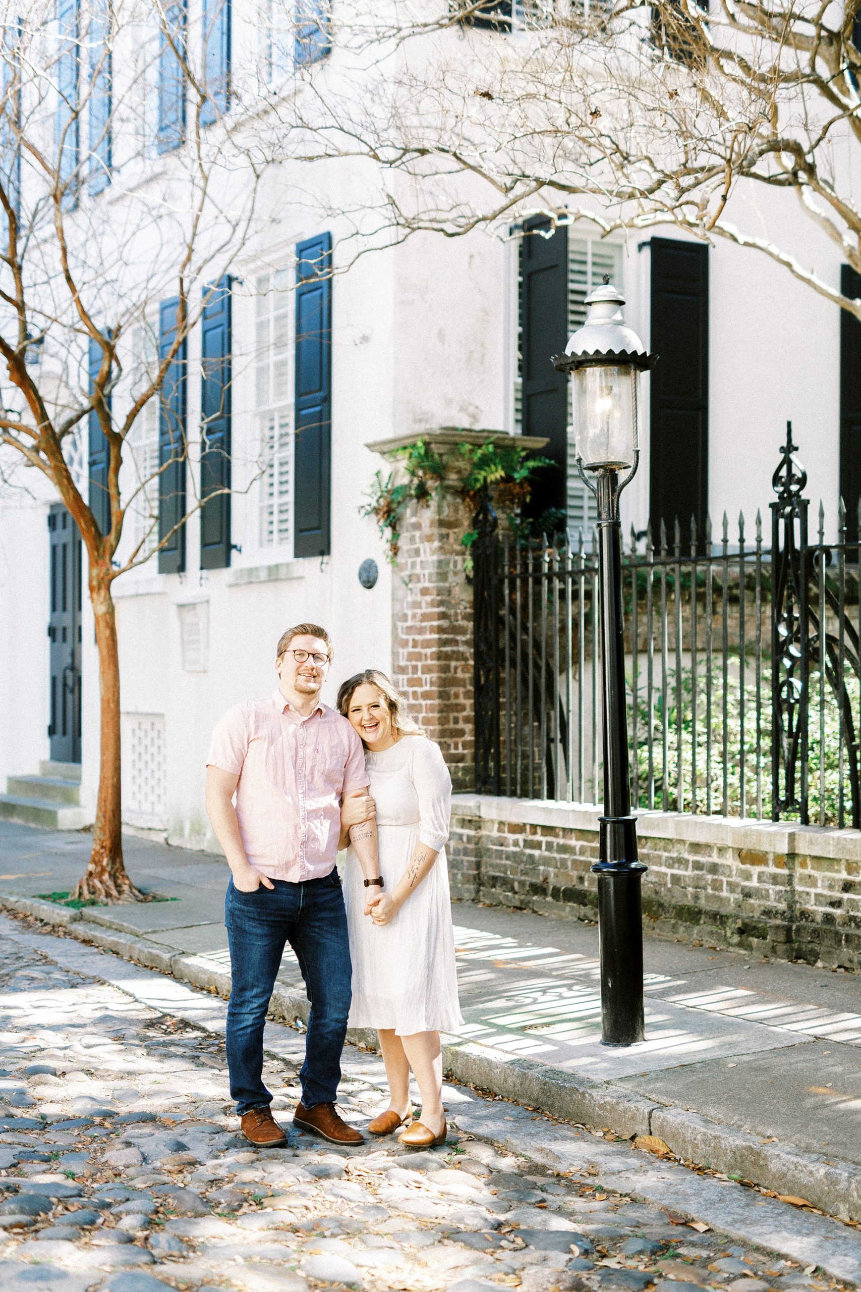married couple hugs on sidewalk in downtown Charleston
