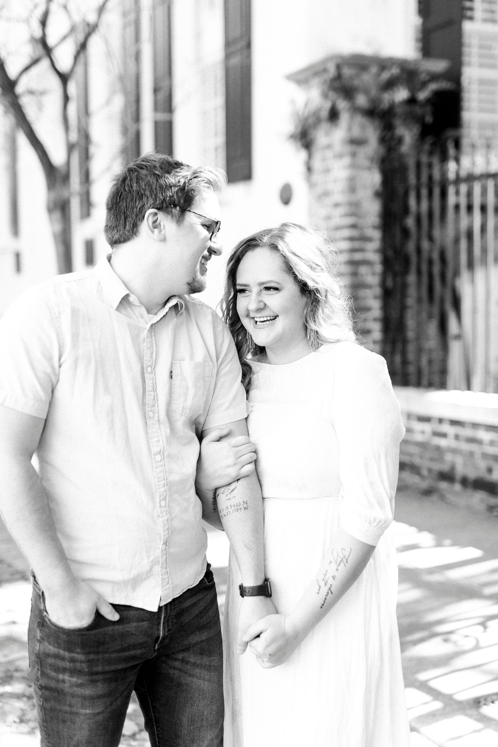 married couple holds hands walking in downtown Charleston