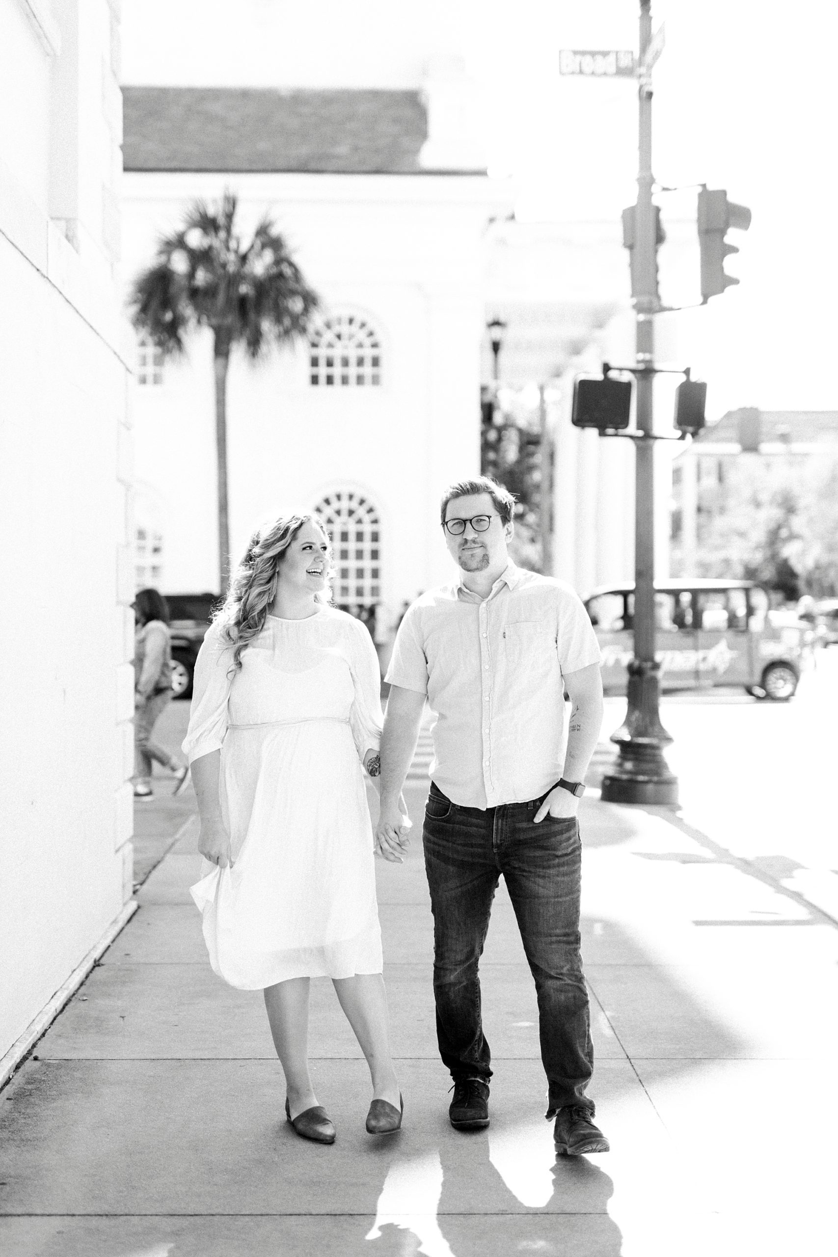 couple holds hands on street in downtown Charleston