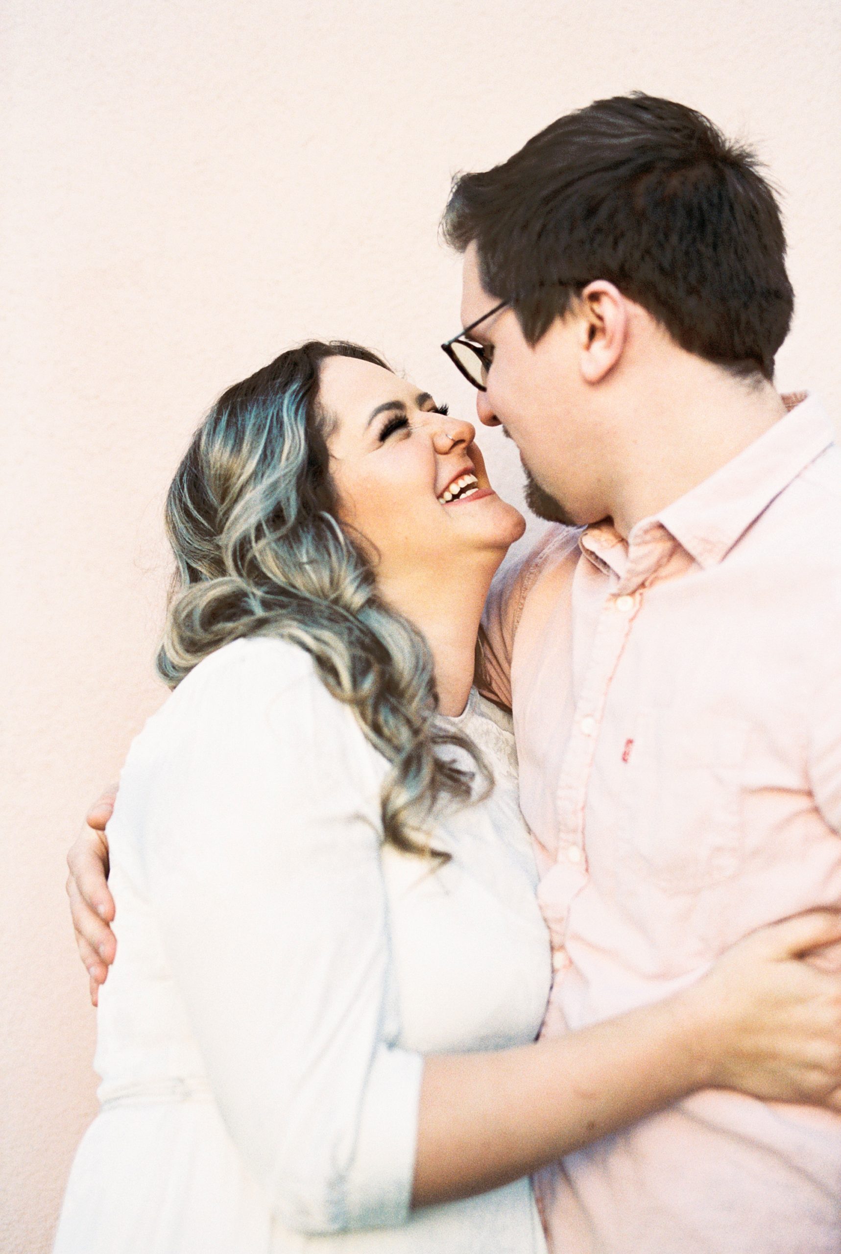 woman laughs looking up at husband during downtown Charleston anniversary portraits