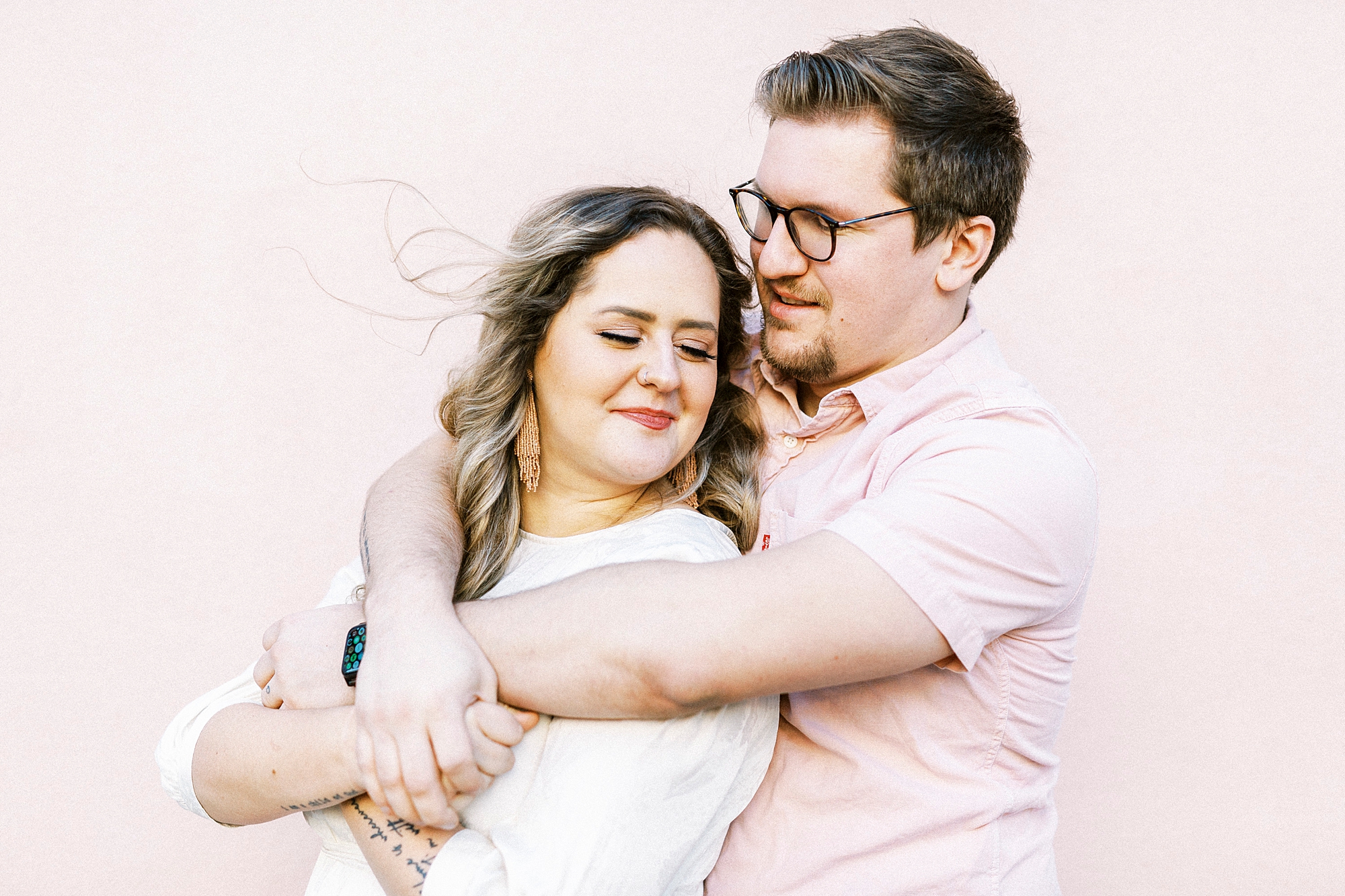 man hugs wife against pink wall of The Mills House in Charleston SC