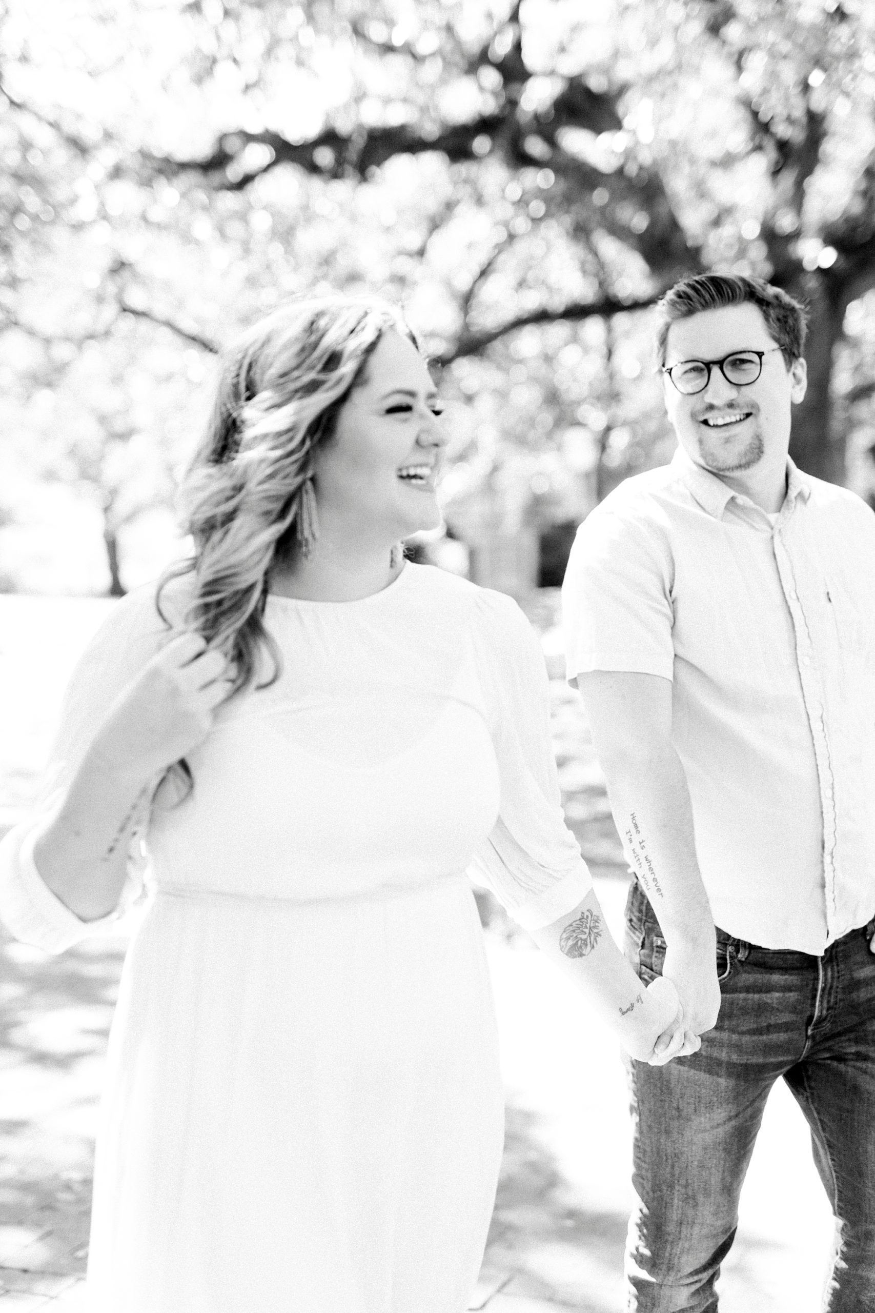 married couple holds hands walking through downtown Charleston