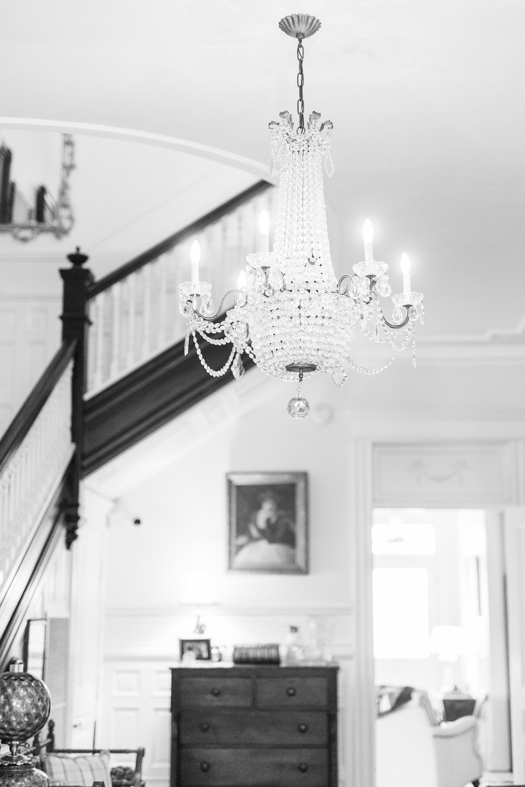 chandelier hangs by staircase in historic home