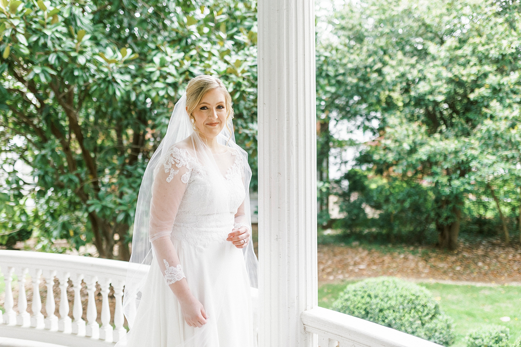 bride leans against column of historic home