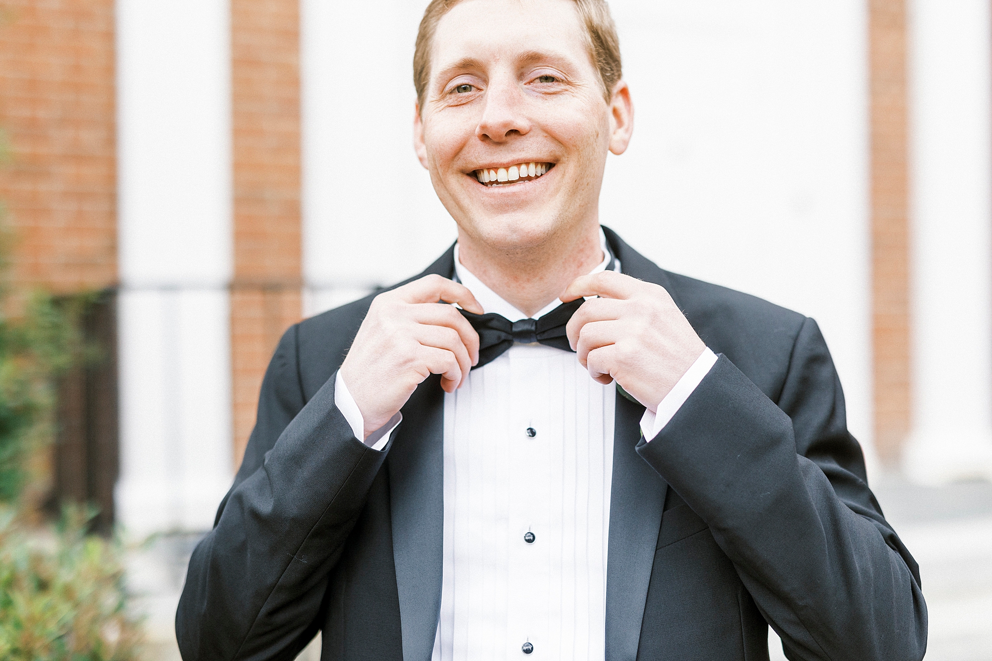 groom adjusts bow tie before NC wedding day