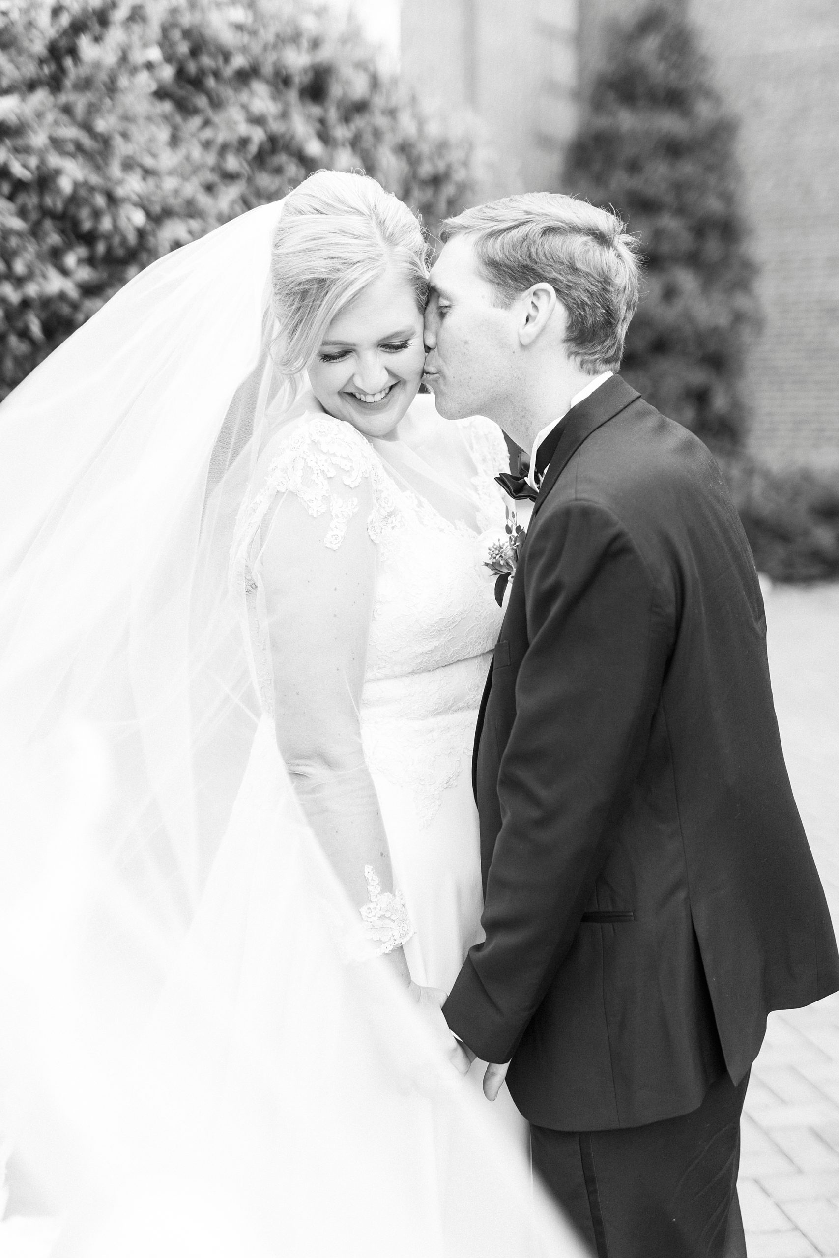 groom kisses bride's cheek during Hotel Concord wedding photos