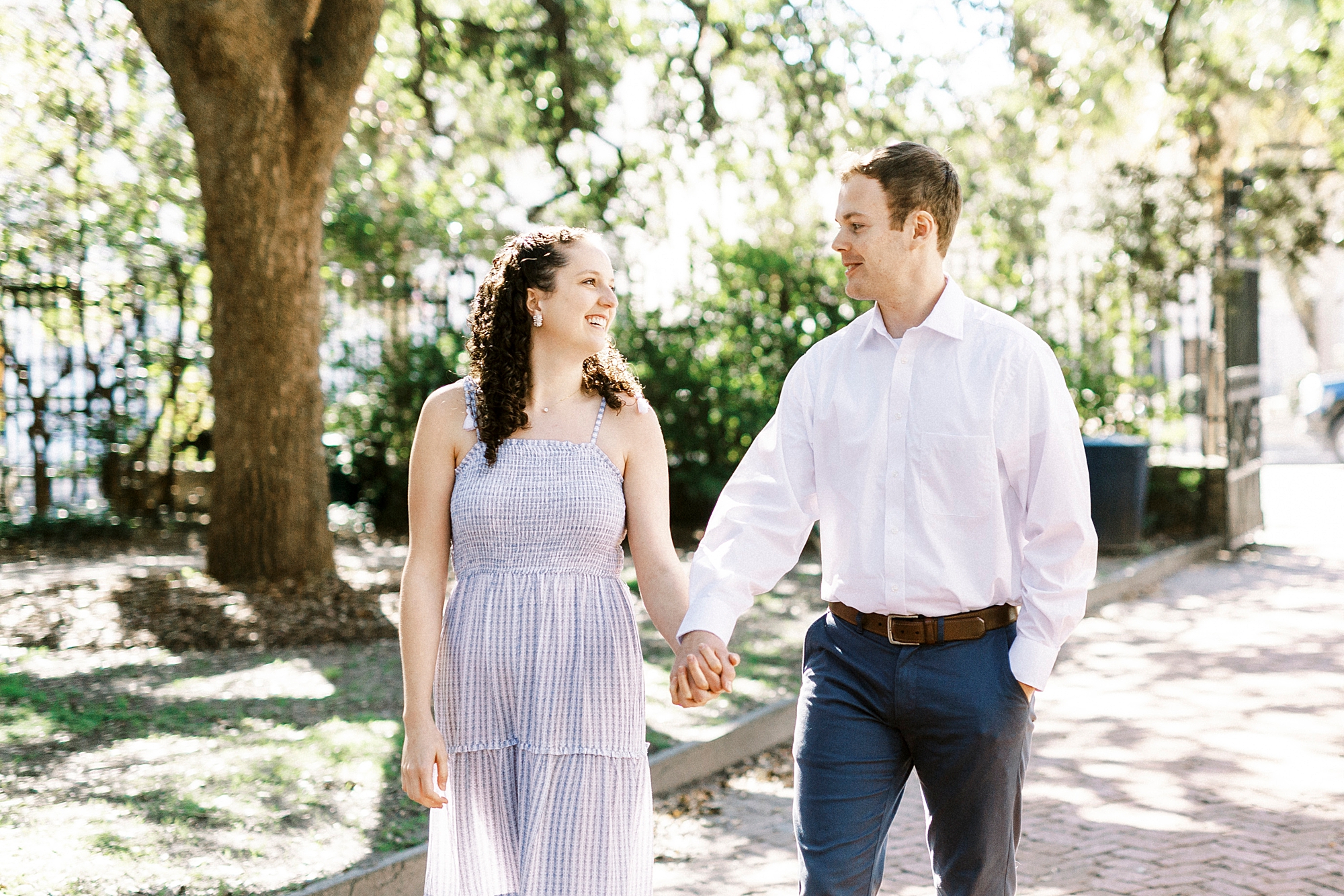 couple holds hands walking through Washington Park