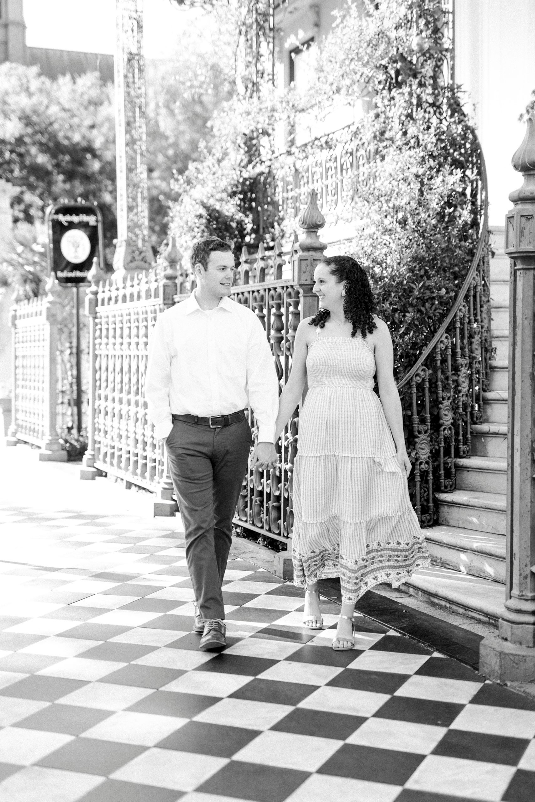 couple holds hands walking through Washington Park