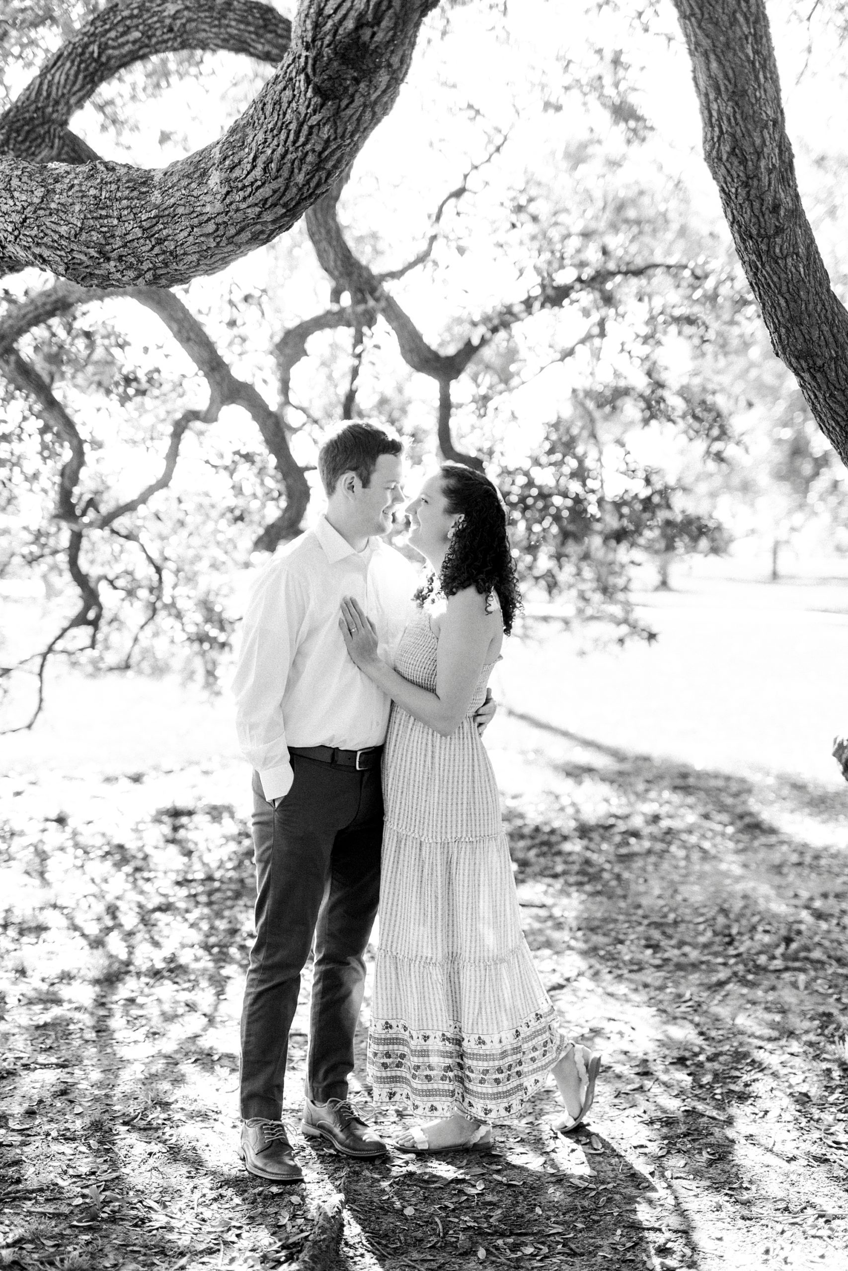 husband and wife hug under trees in Washington Park 