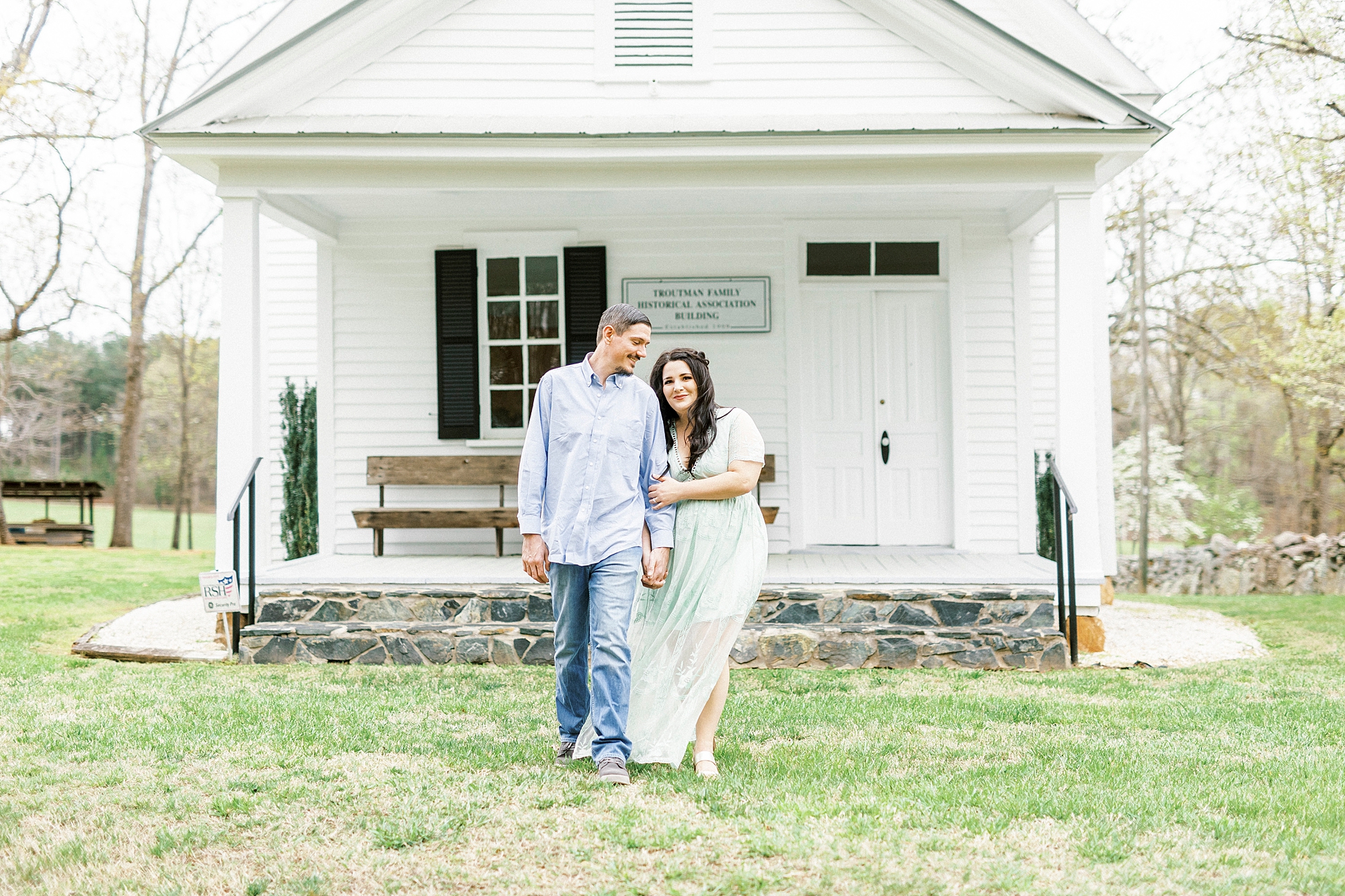 bride and groom walk outside family's white chapel