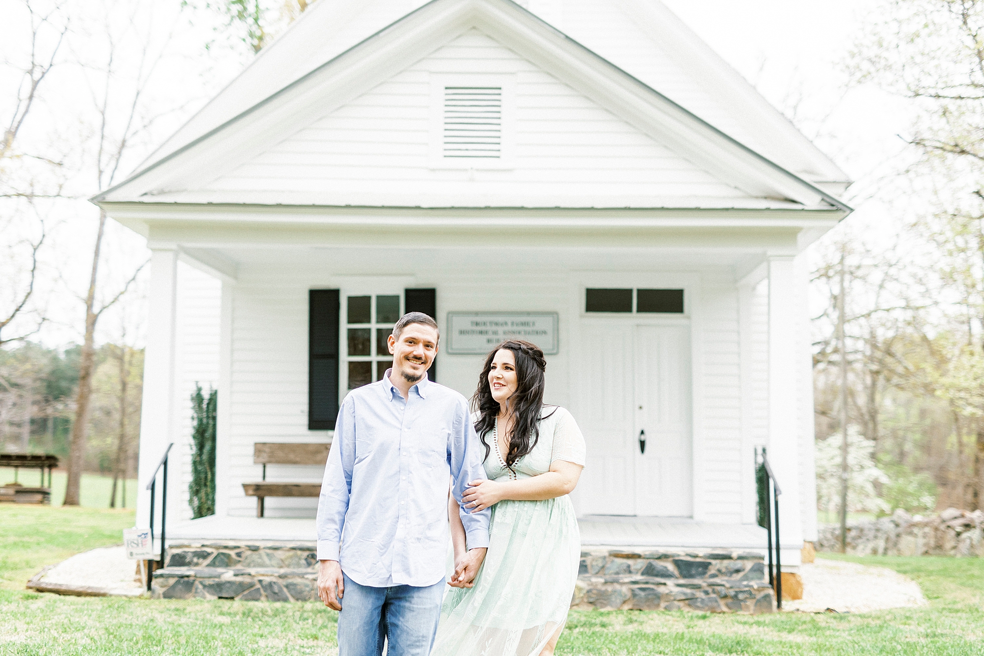bride holds groom's arm during White Chapel engagement session