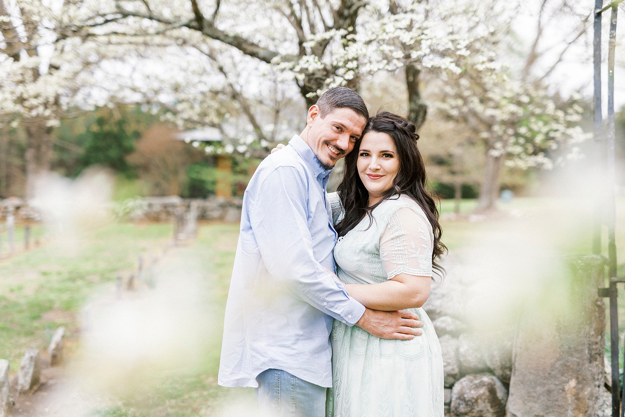 bride and groom hug under white trees