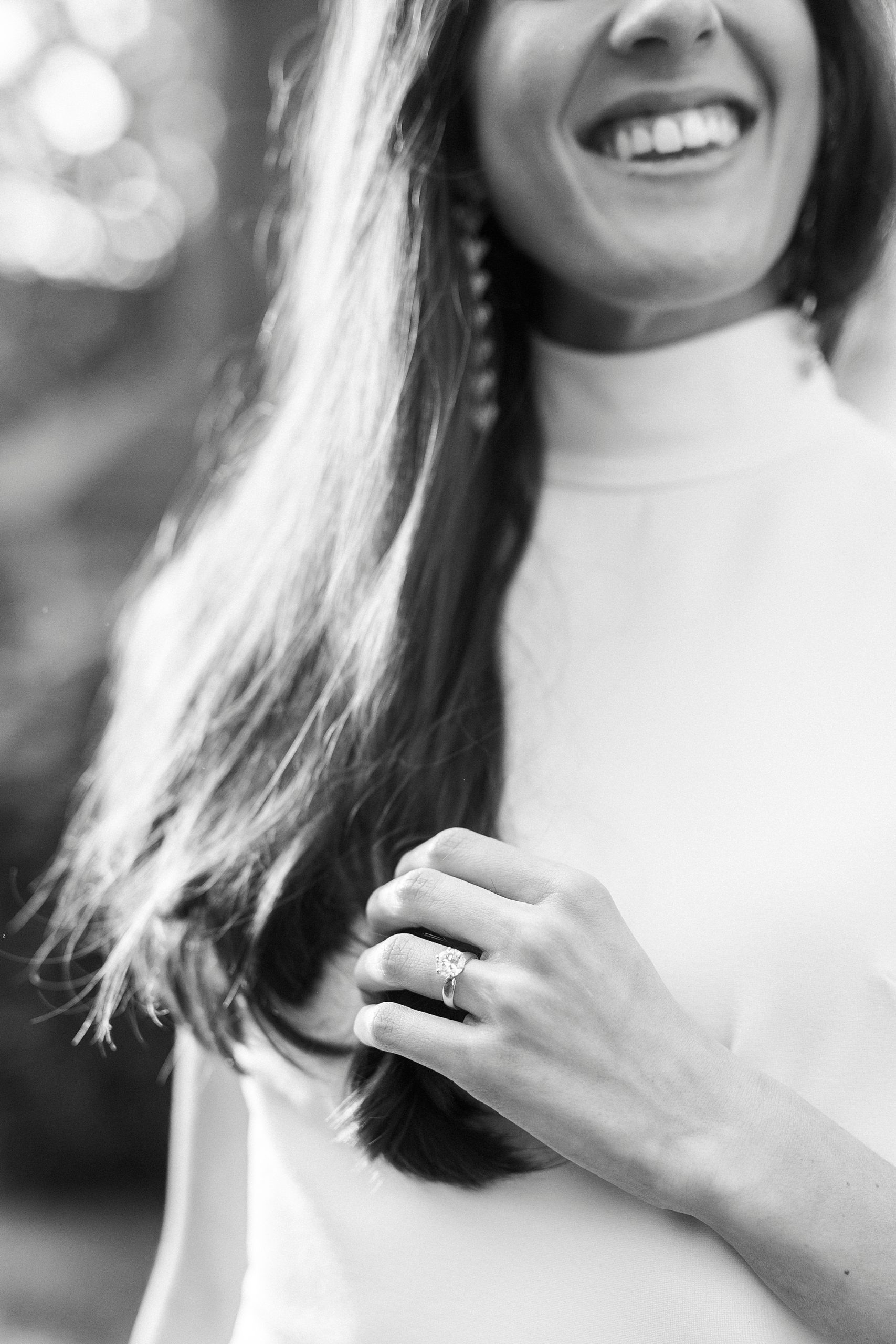 bride runs hands through hair showing off engagement ring