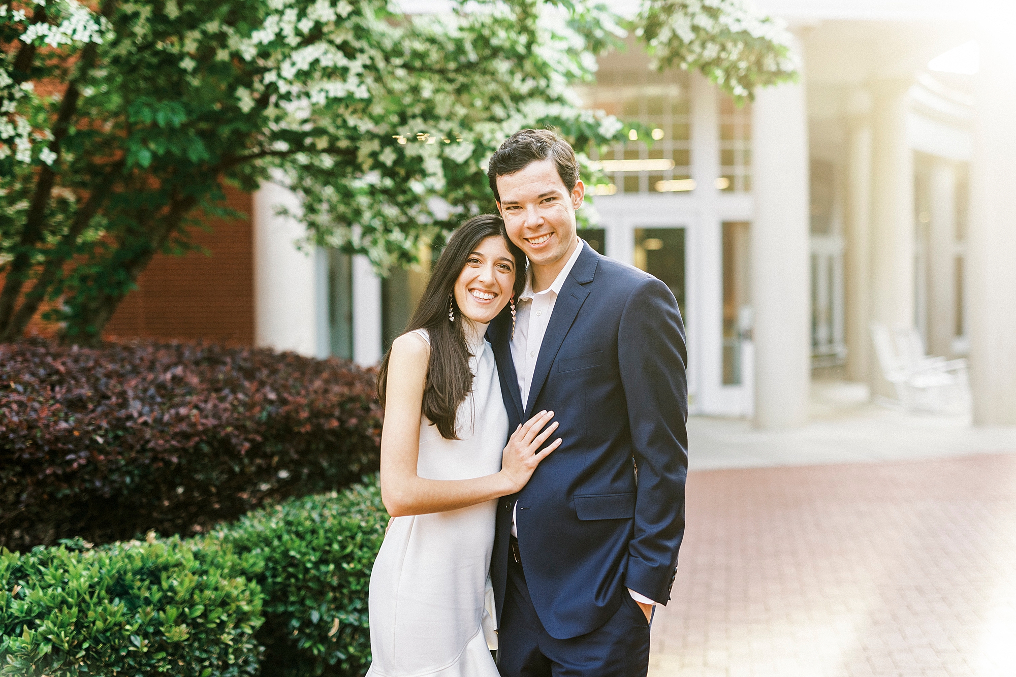 bride and groom hug together at sunset at Queens University