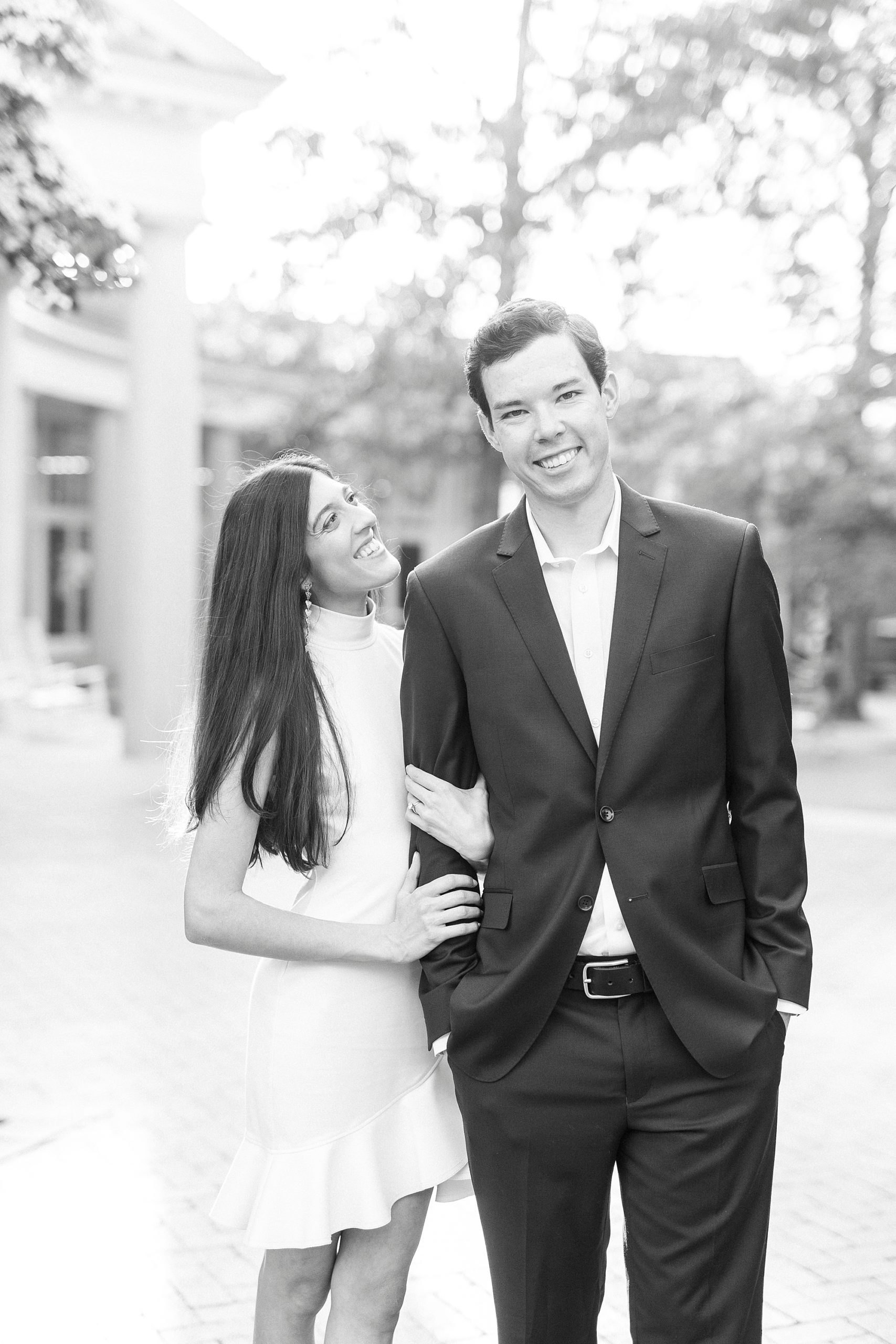 bride holds groom's arm looking up at him during Charlotte engagement photos