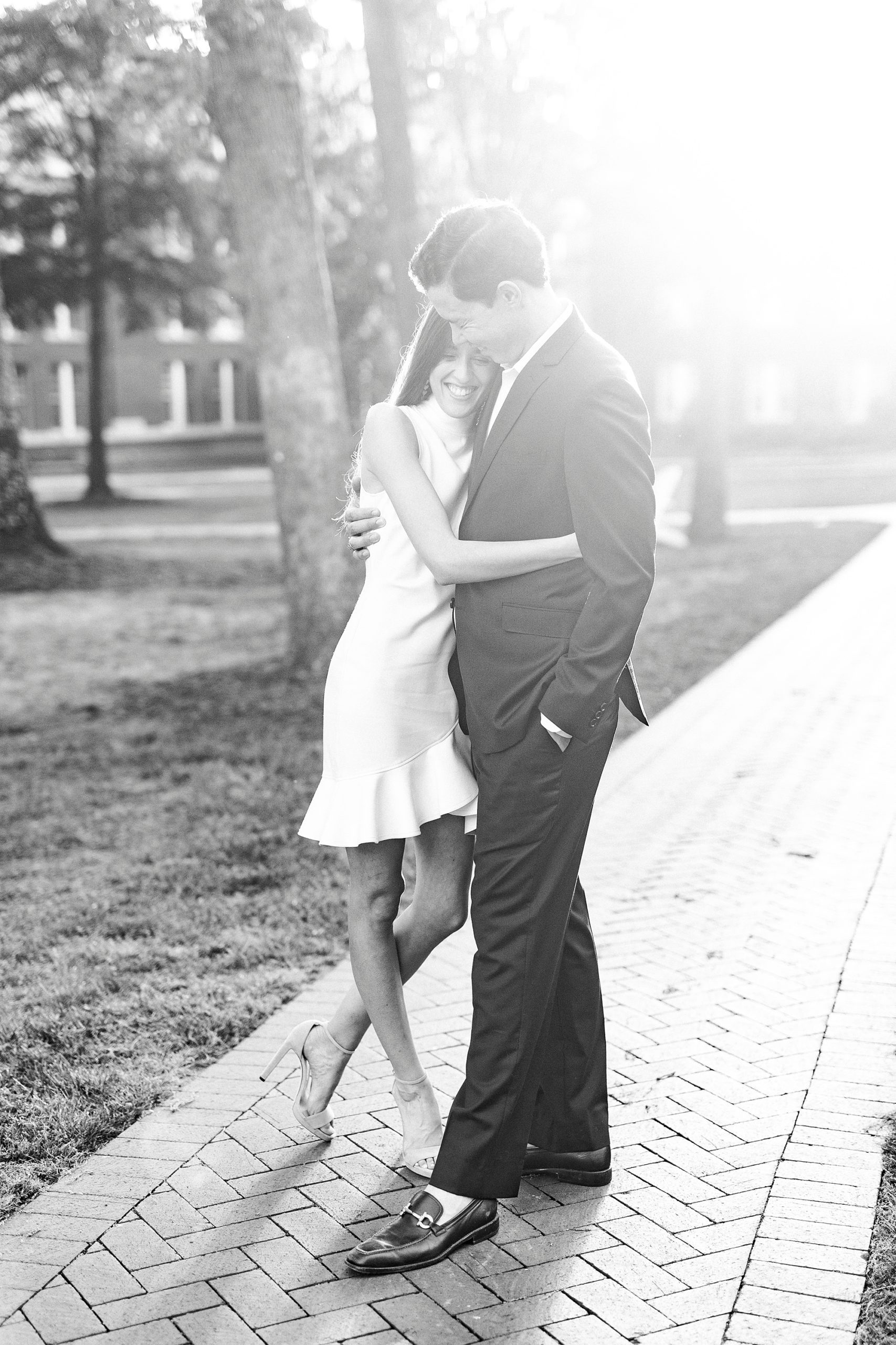 bride hugs groom at sunset on brick patio at Queens University