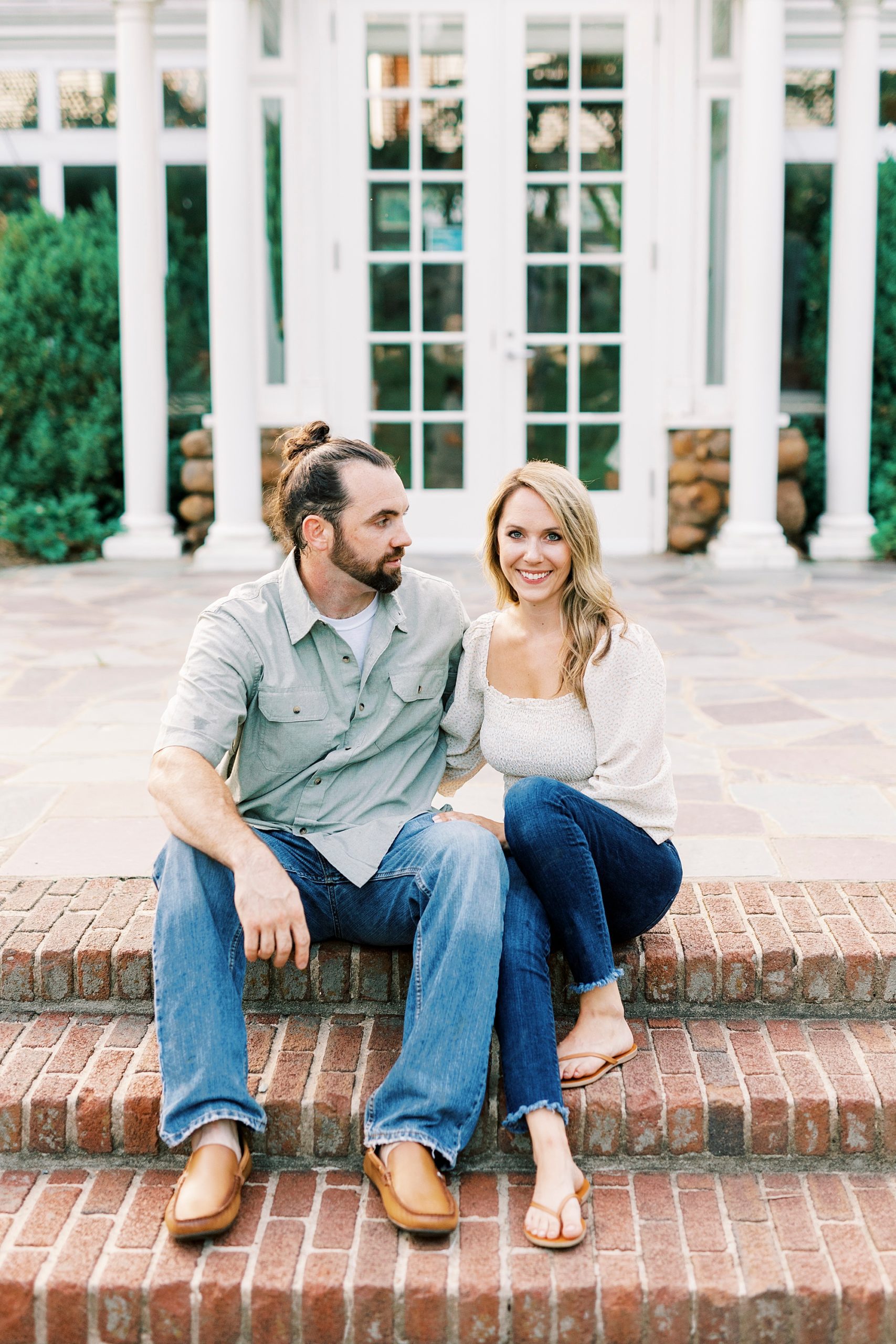 bride and groom sit on steps at Reynolda Gardens