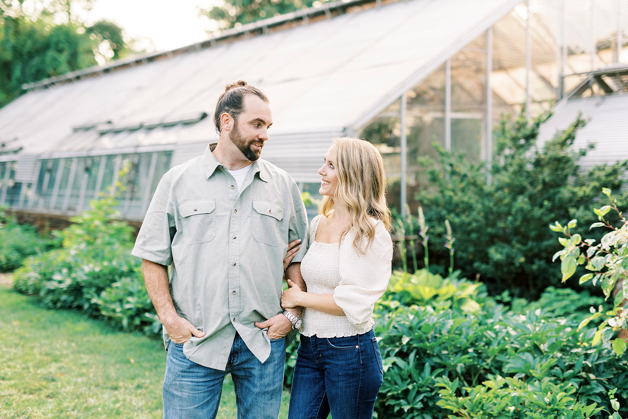bride holds fiance's arm during engagement session in Winston-Salem 