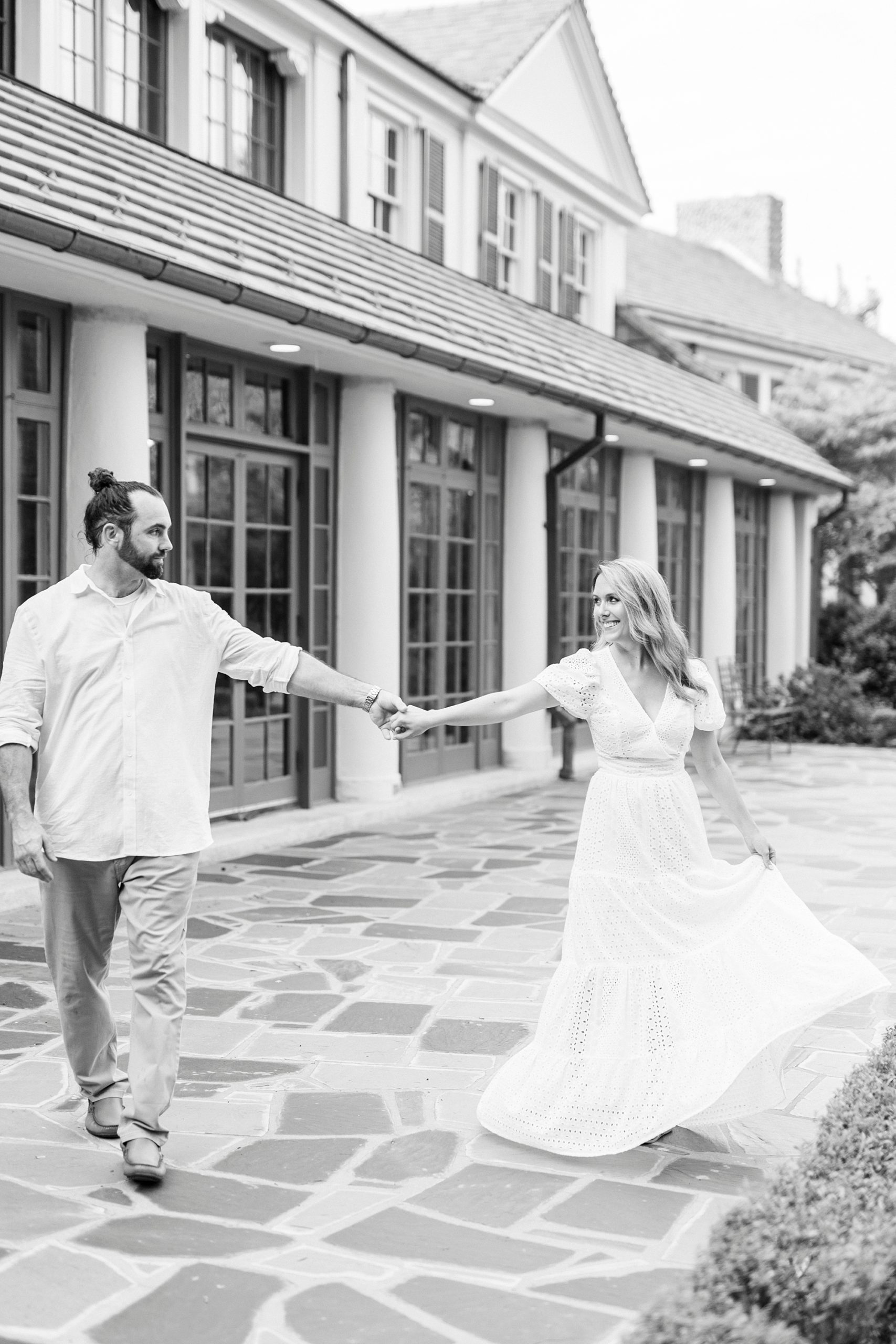 groom twirls bride around outside Reynolda Gardens