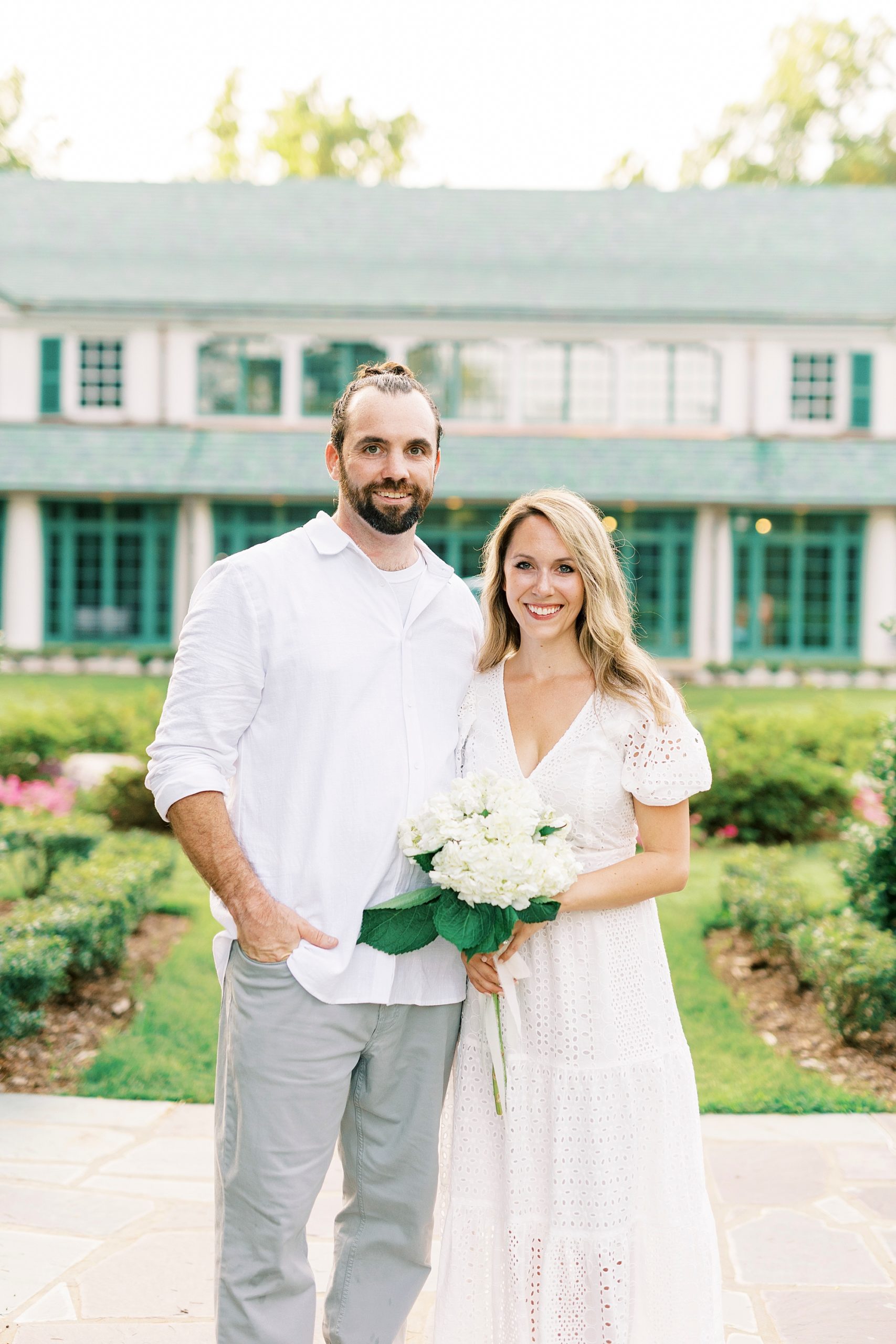 bride and groom stand holding bouquet of white flowers in Winston-Salem NC 