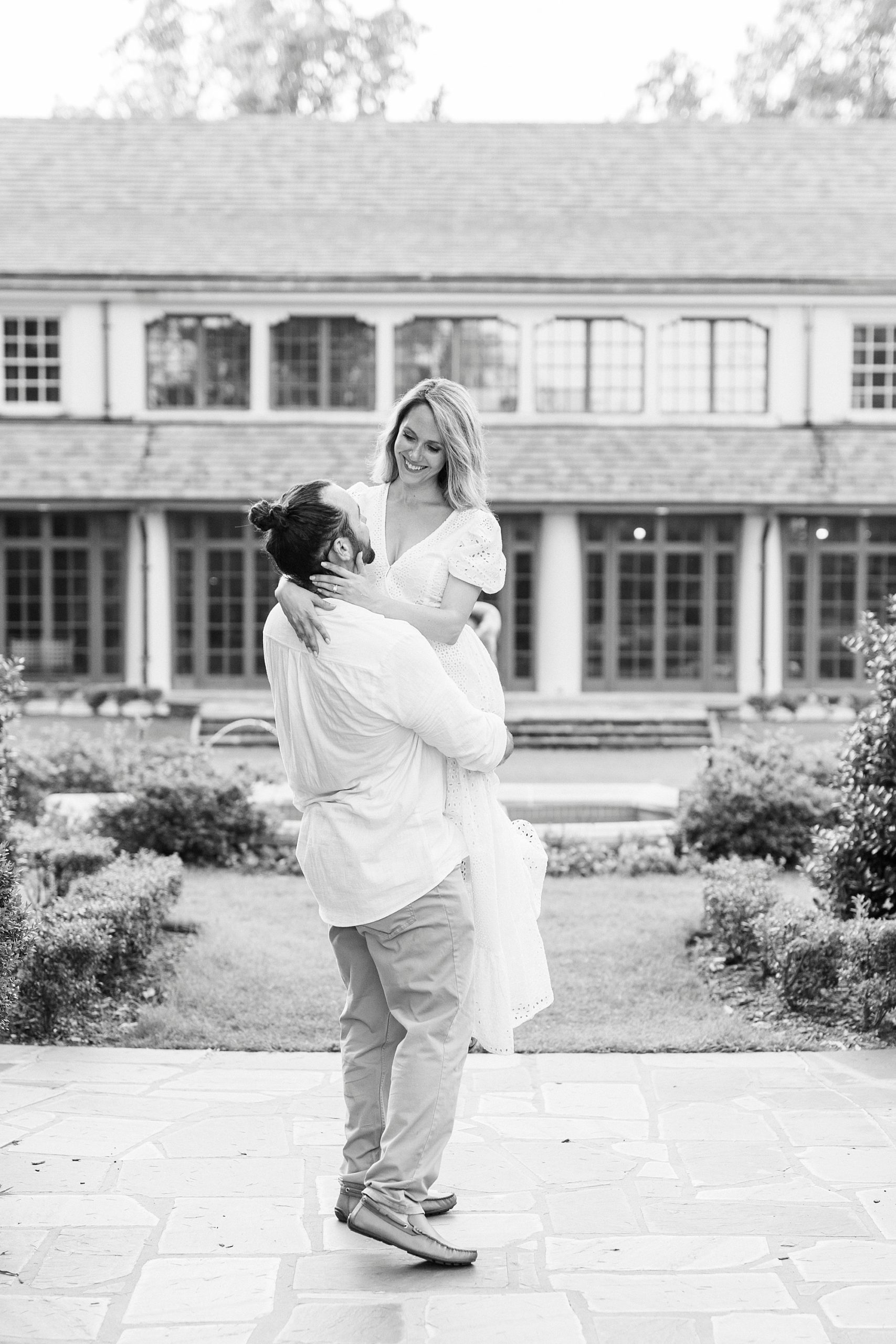 groom lifts bride up during Reynolda Gardens engagement session