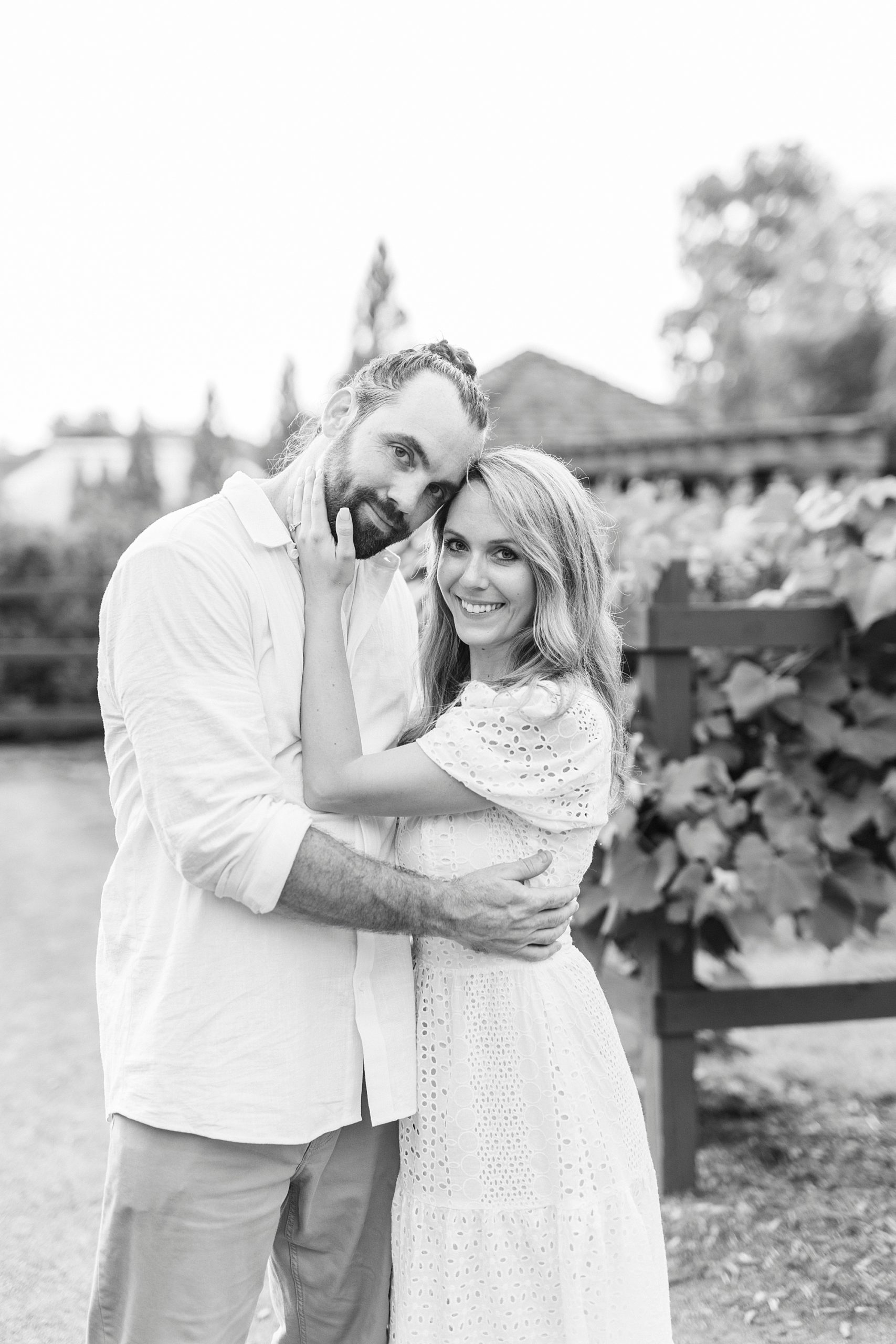 couple leans heads together hugging at Reynolda Gardens