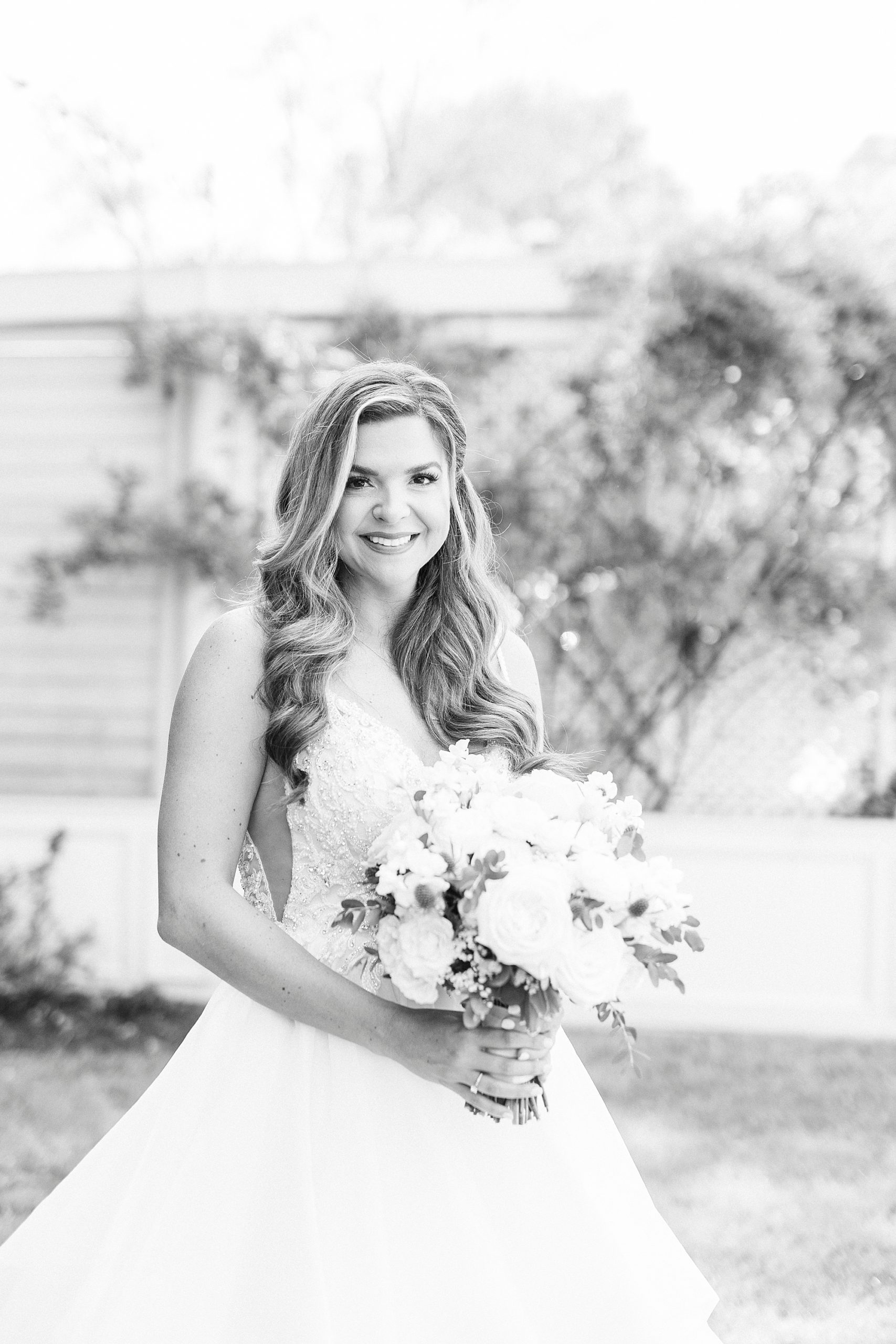 bride holds bouquet posing in gardens of Separk Mansion