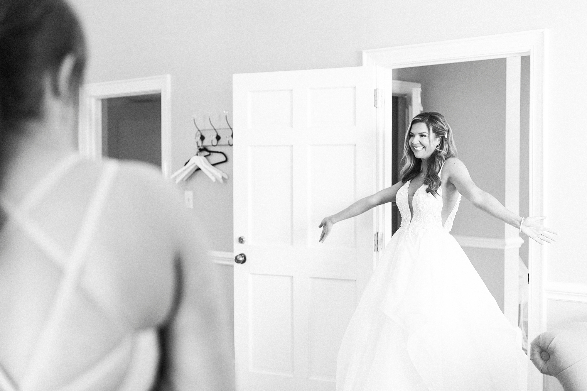 bride shows off wedding gown to bridesmaids before NC wedding