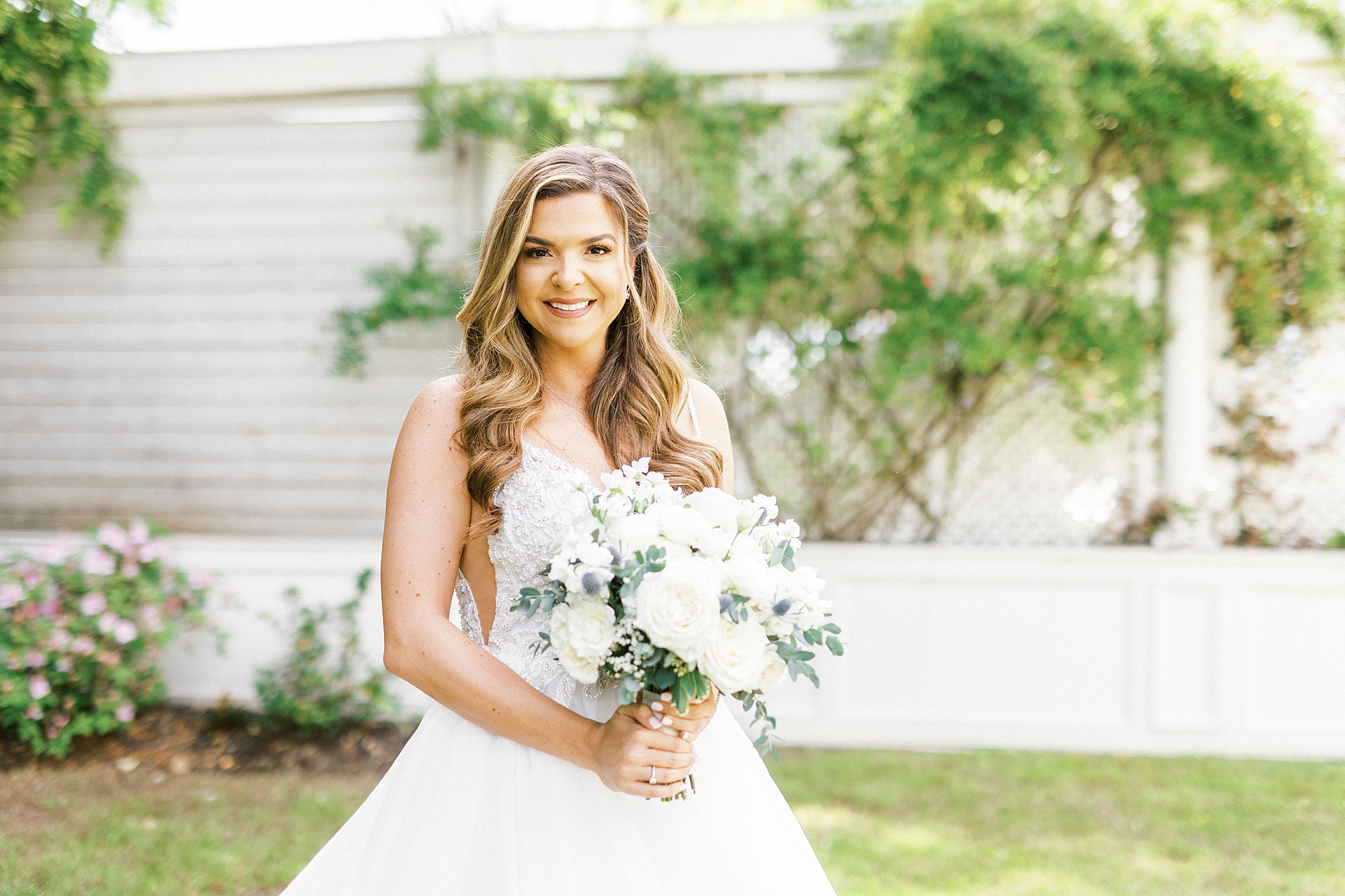 bride holds bouquet of white roses in gardens of Separk Mansion