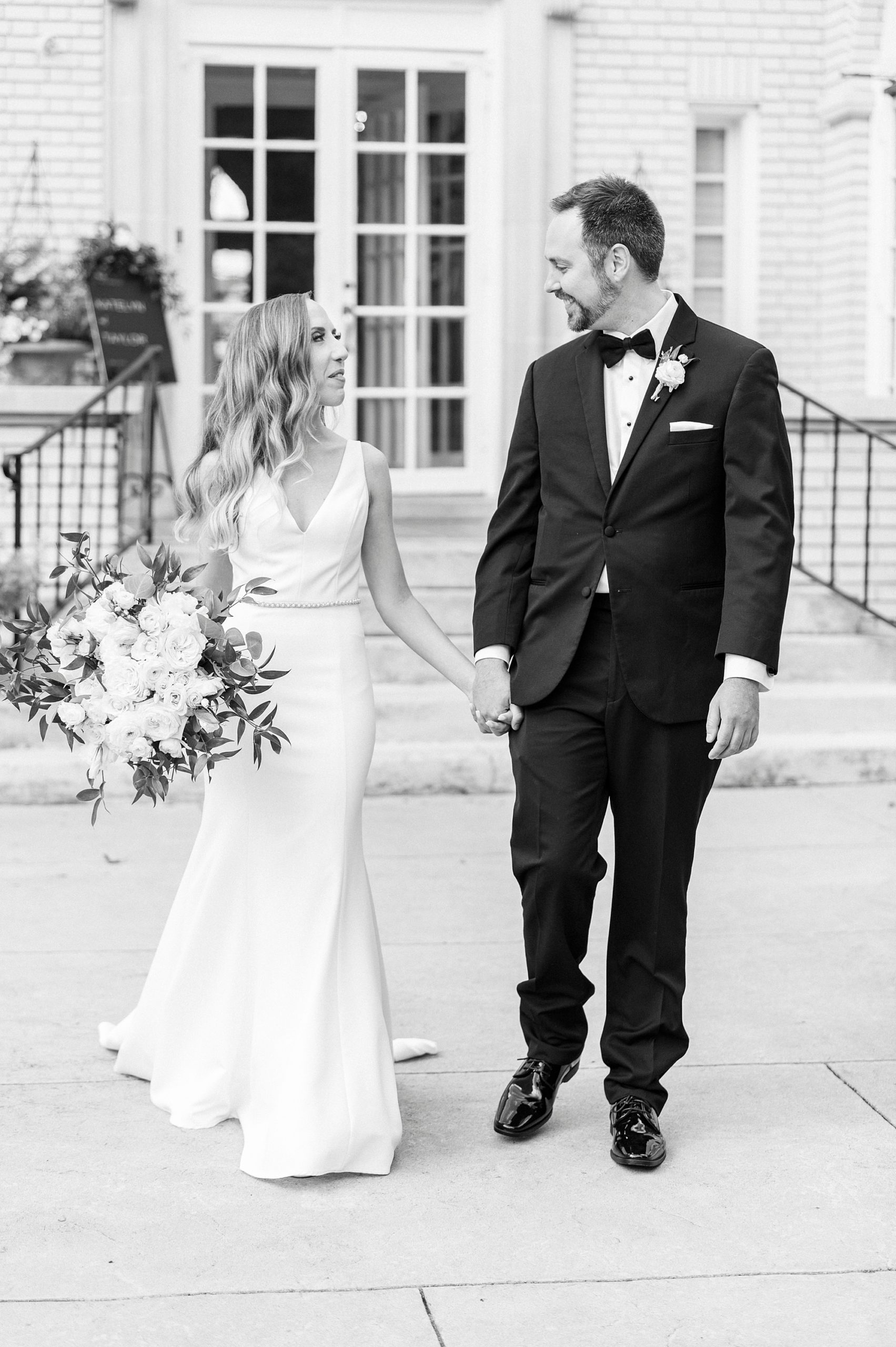 newlyweds hold hands walking outside Separk Mansion