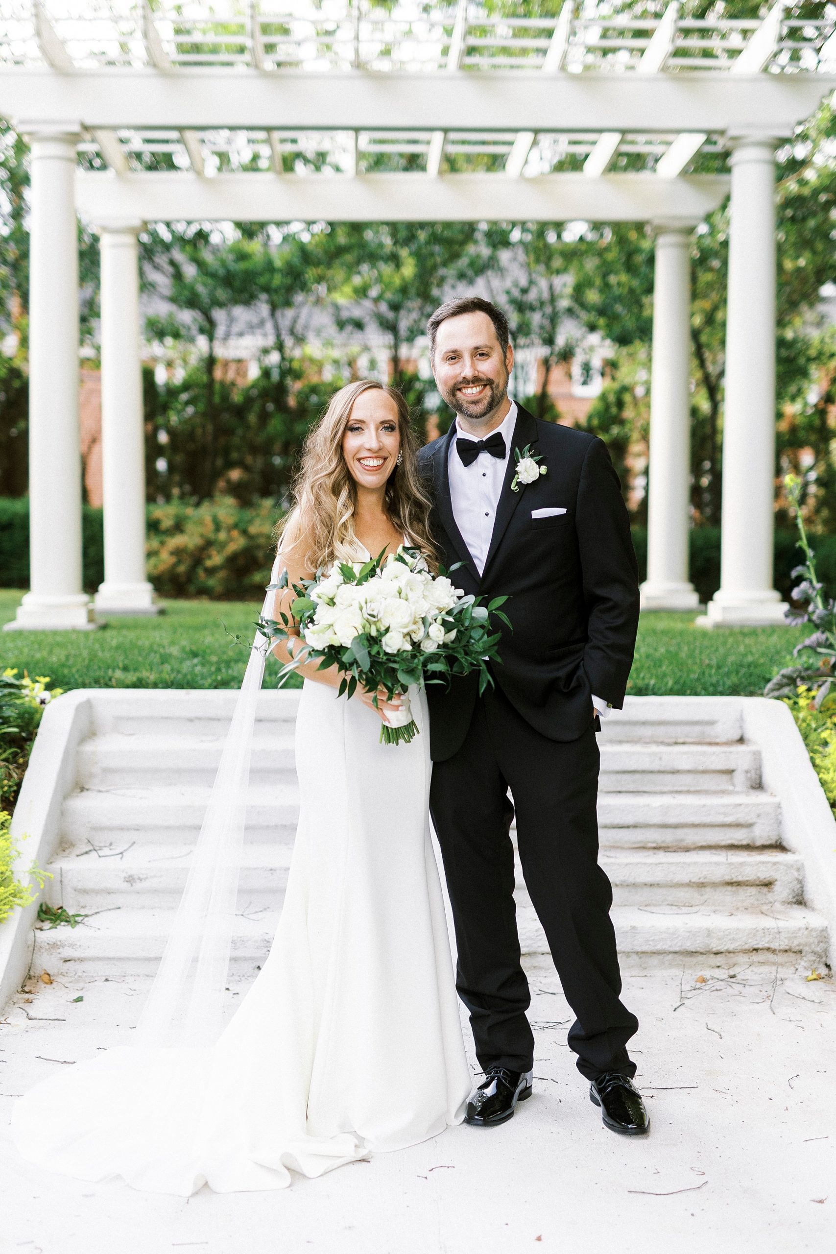 newlyweds pose by arbor in gardens at Separk Mansion