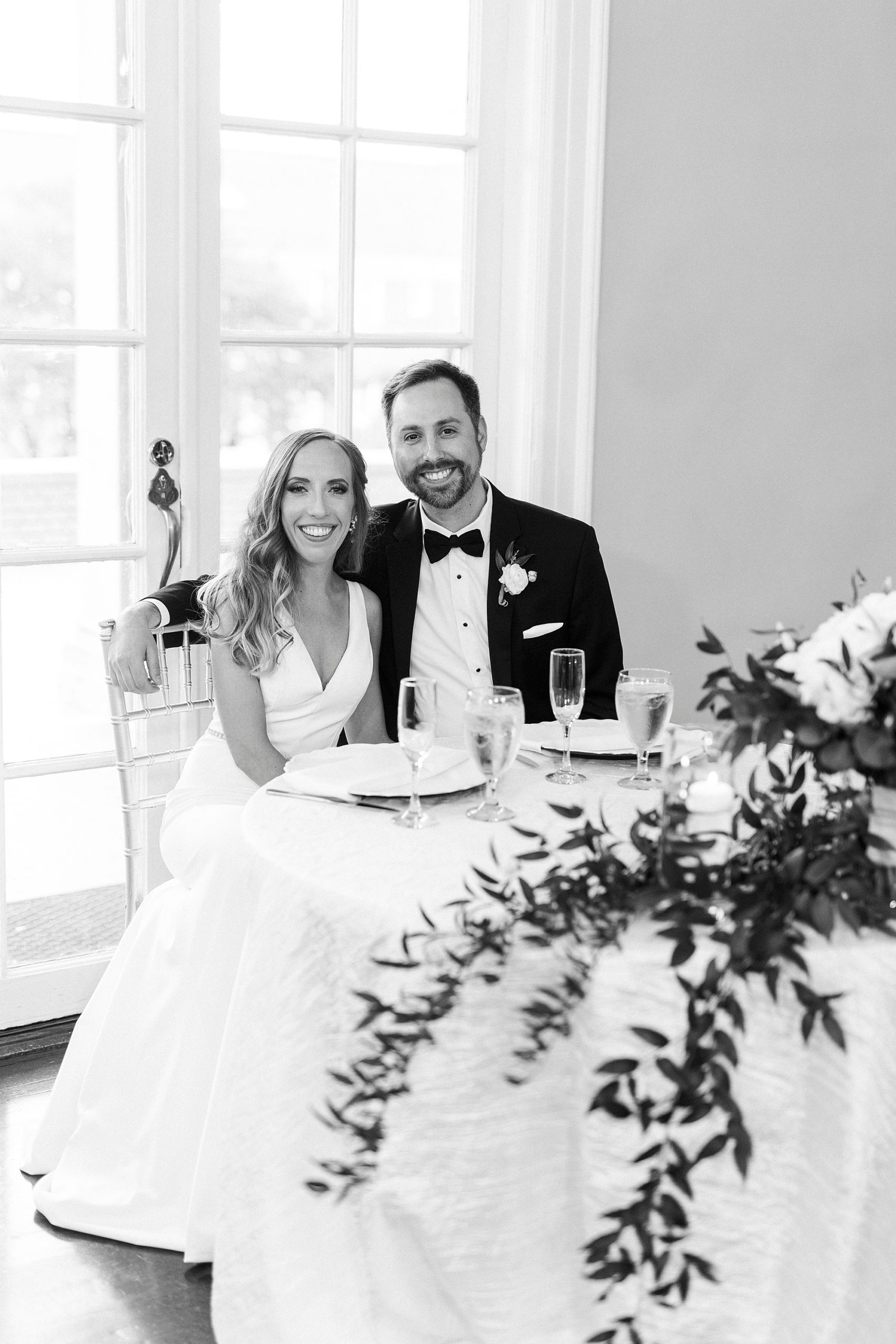 newlyweds sit together at head table during Separk Mansion wedding reception