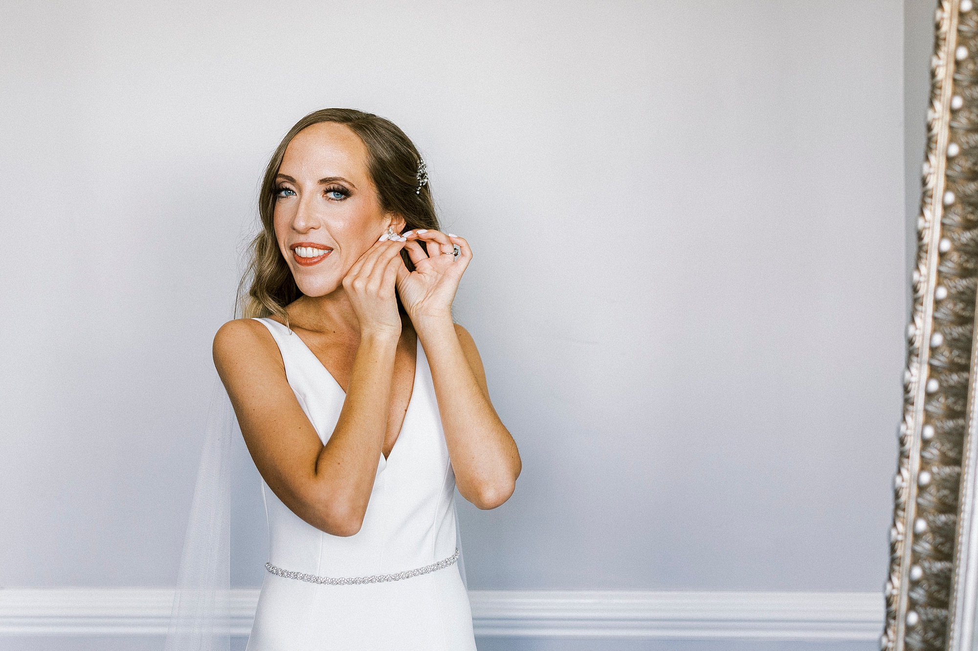 bride adjusts earrings before NC wedding day