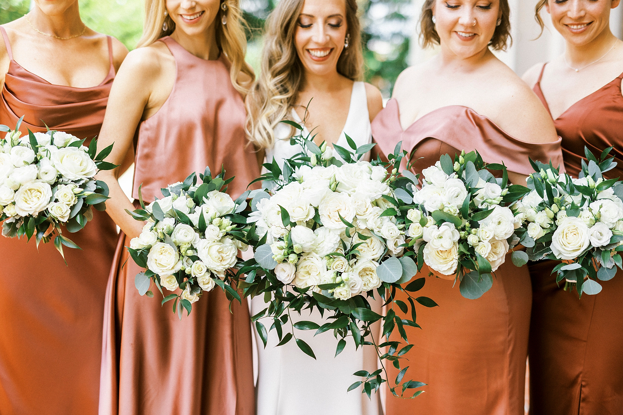 bride and bridesmaids hold ivory bouquets outside Separk Mansion