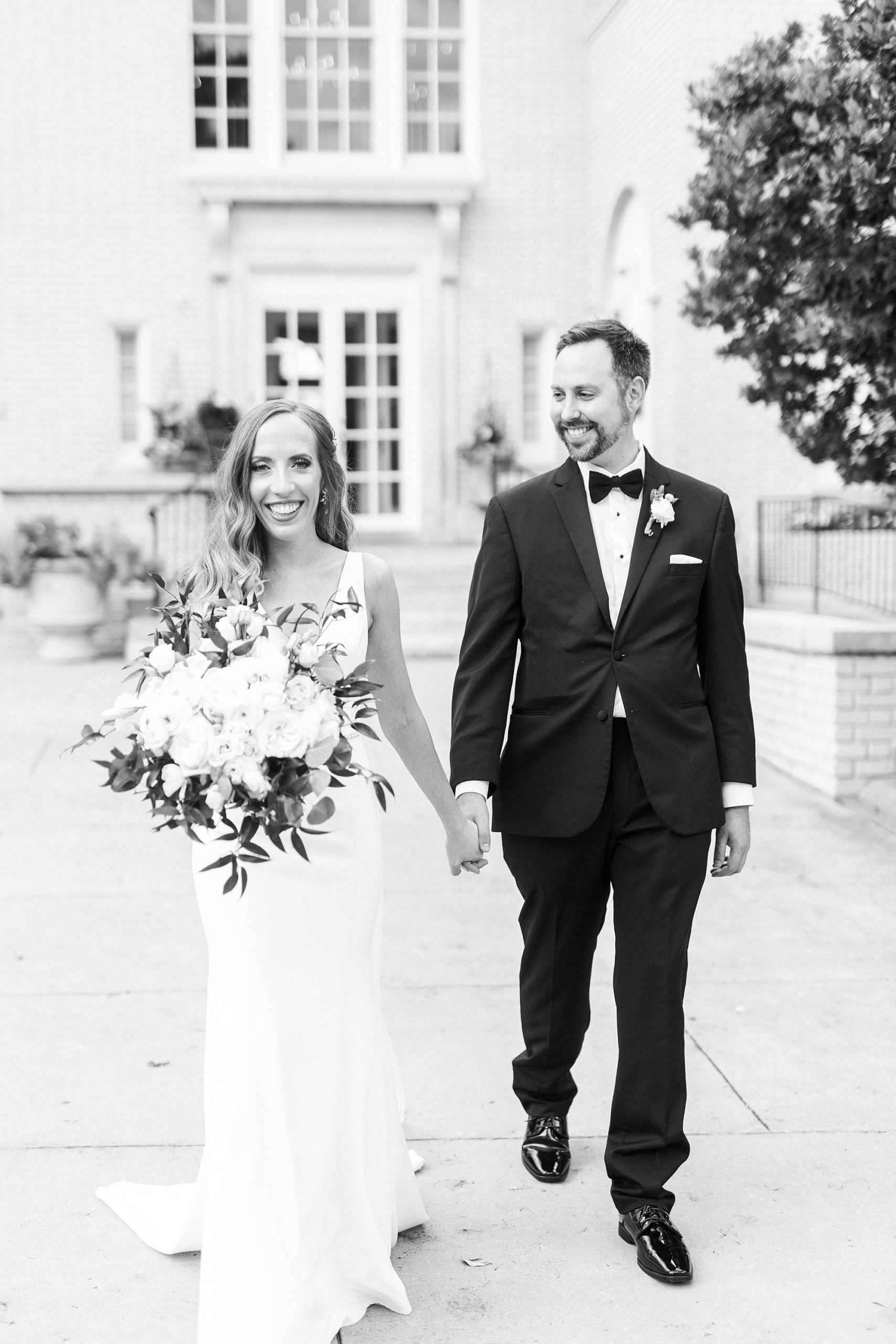 bride and groom hold hands walking through gardens in Gastonia NC