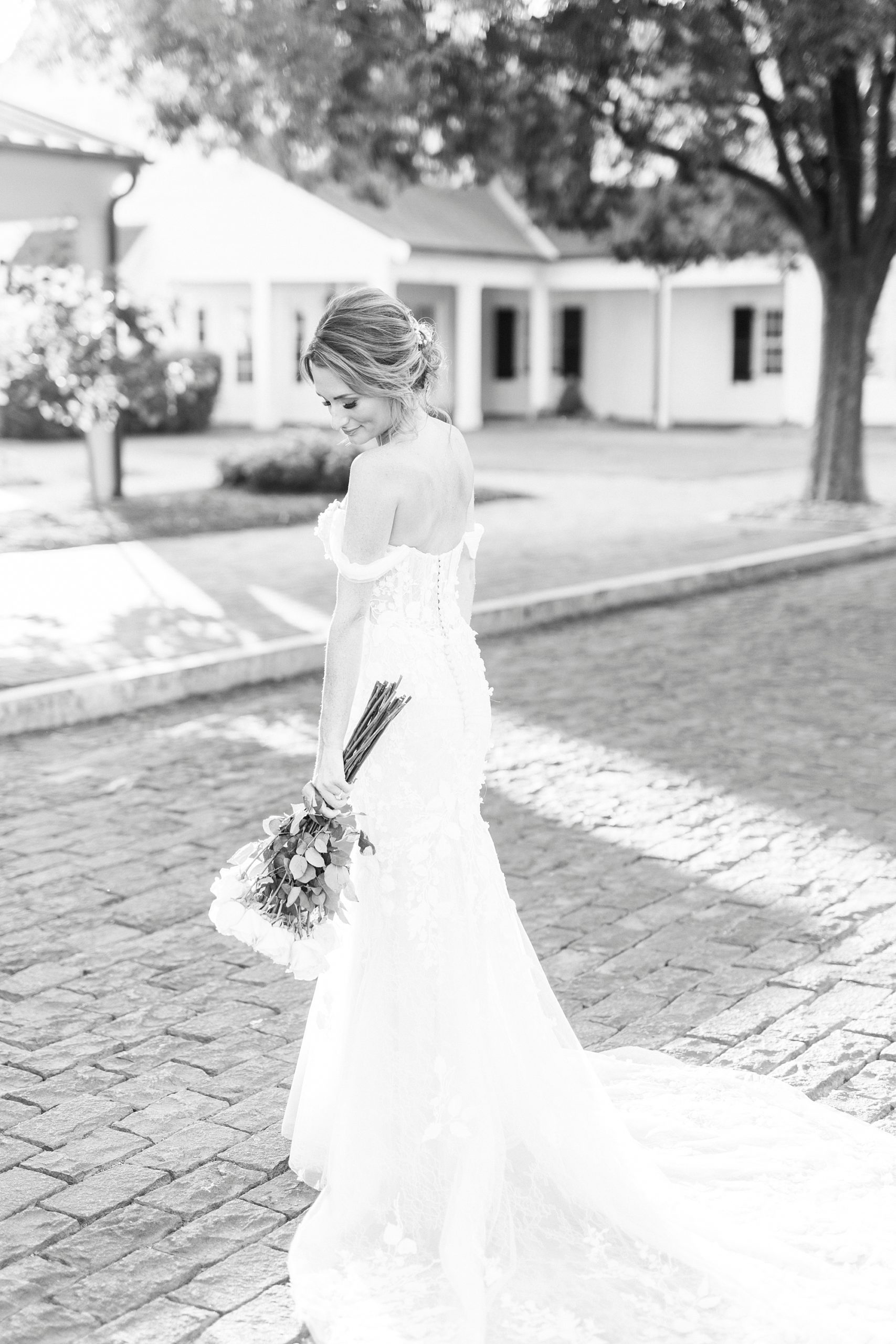 bride looks down at bouquet by her side during Trump National Golf Club bridal portraits