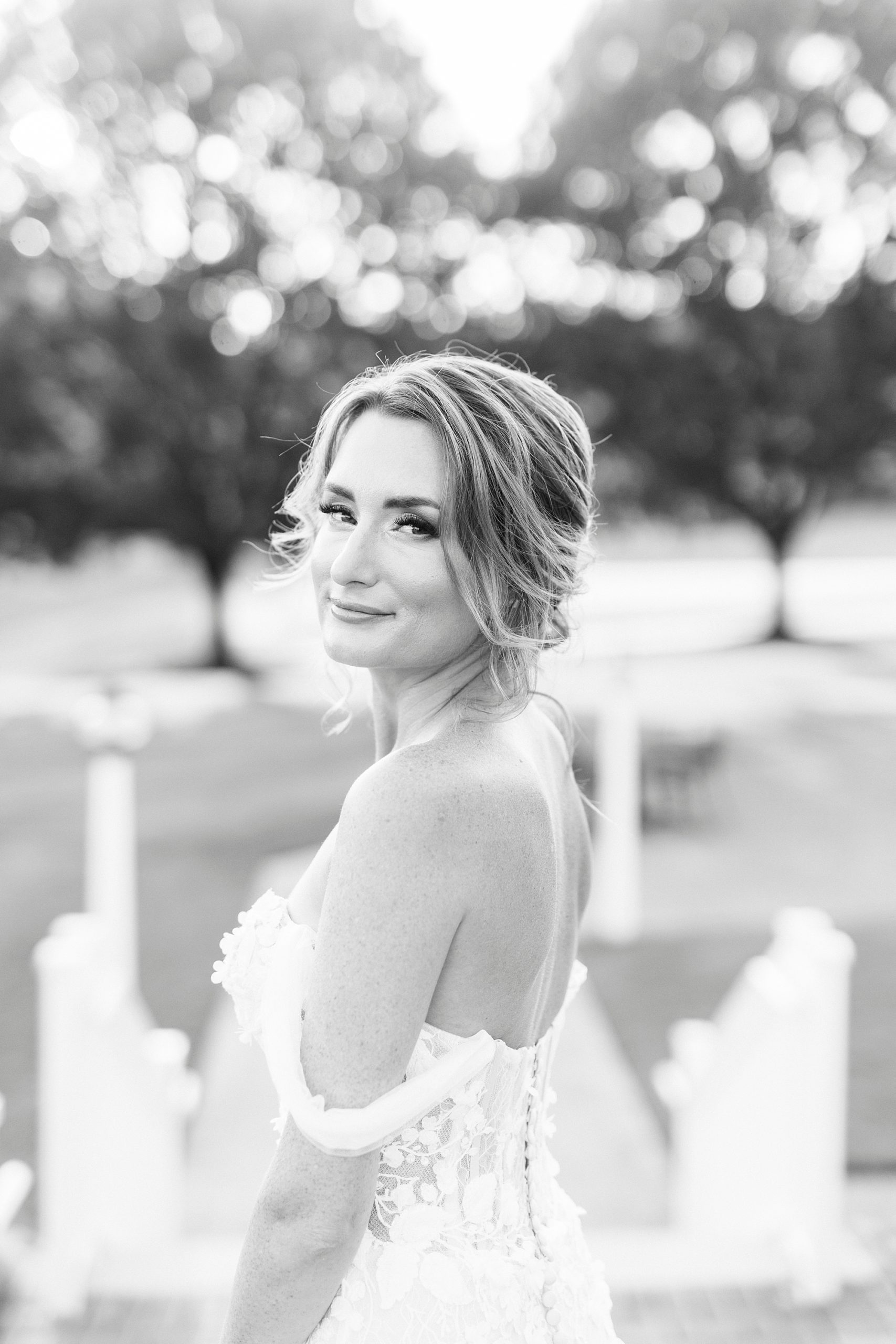 bride smiles over her shoulder during Trump National Golf Club bridal portraits
