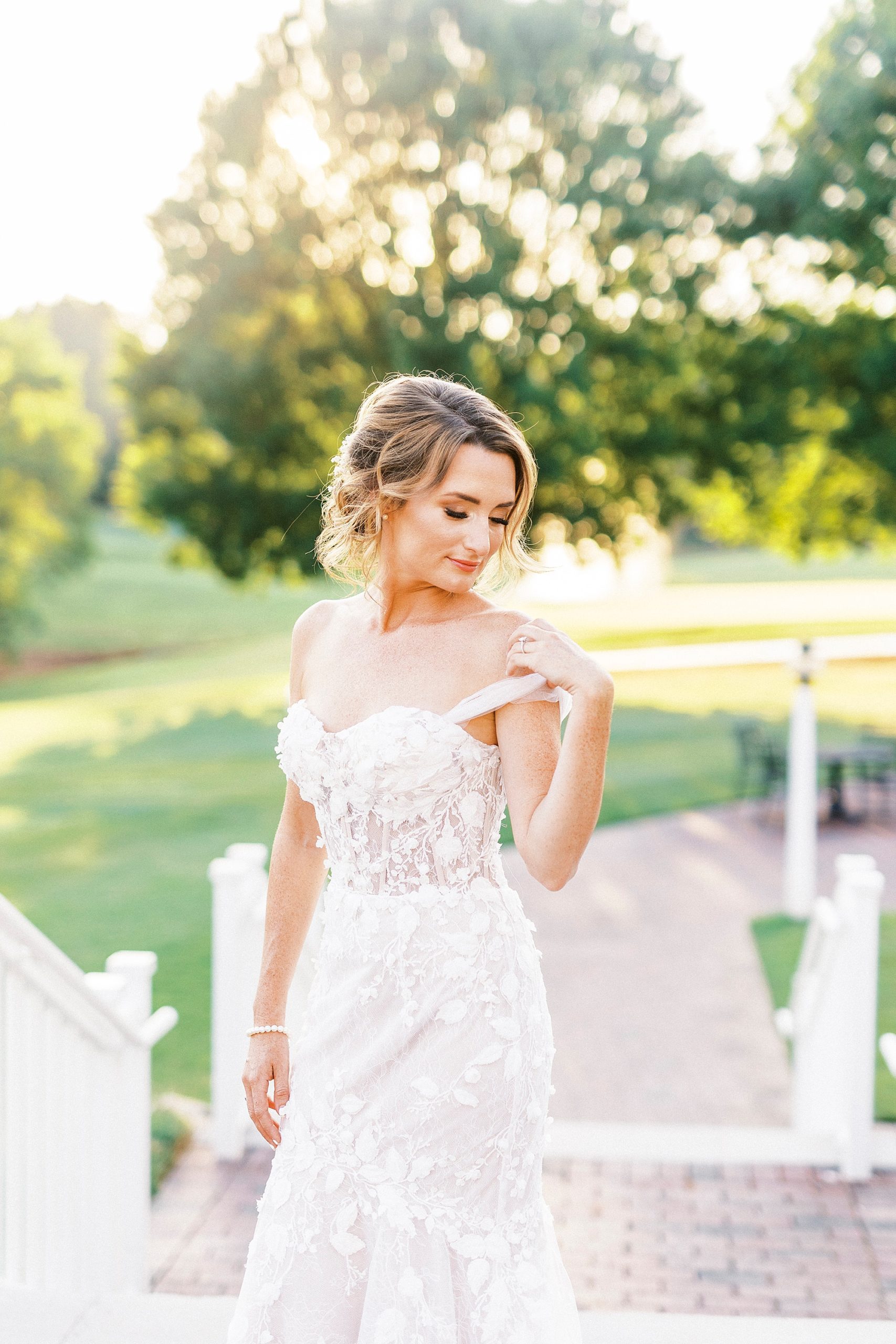 bride looks over shoulder during sunset bridal session on pathway