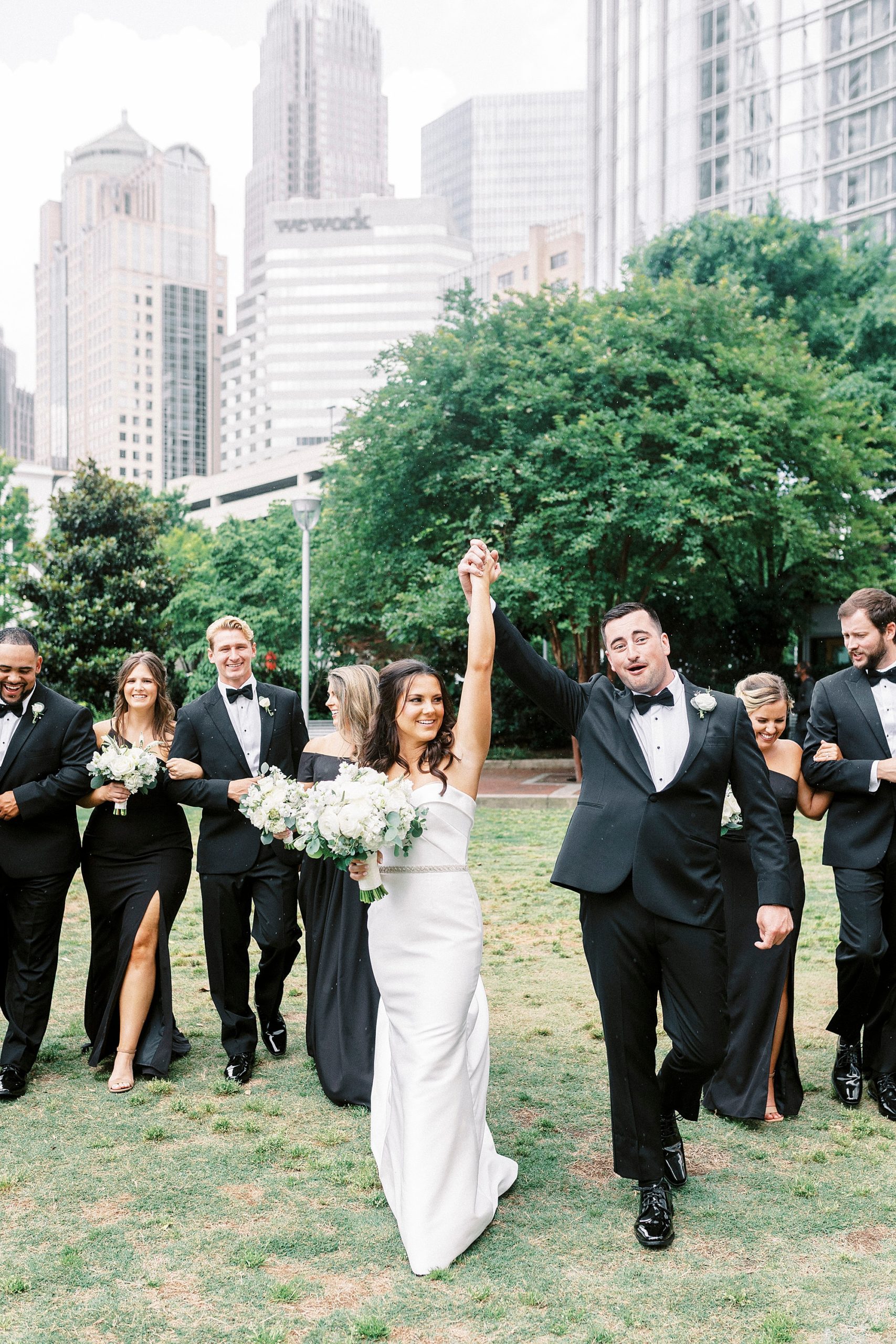 newlyweds cheer walking through park in Charlotte NC