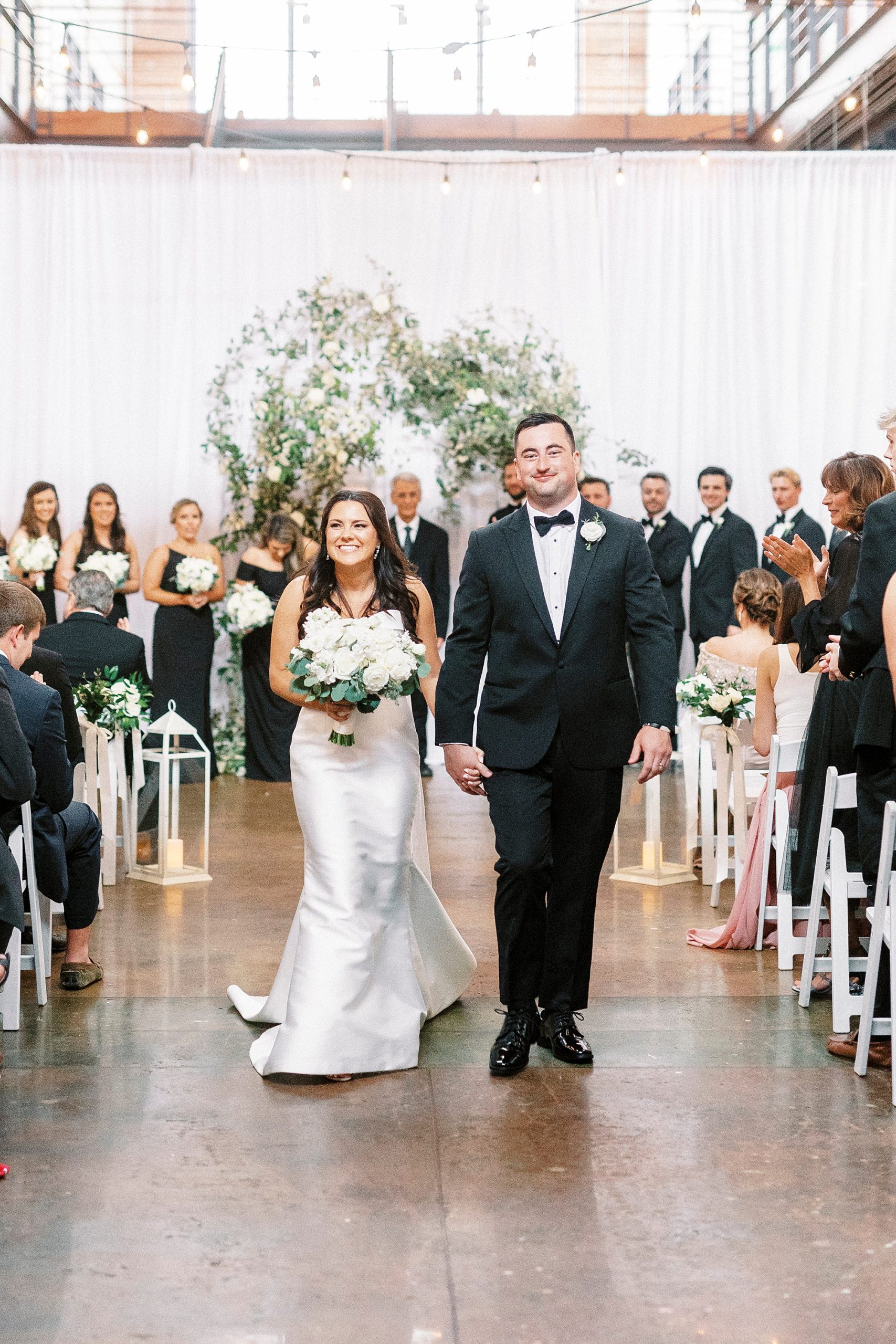 newlyweds walk up aisle at Design Atrium after ceremony