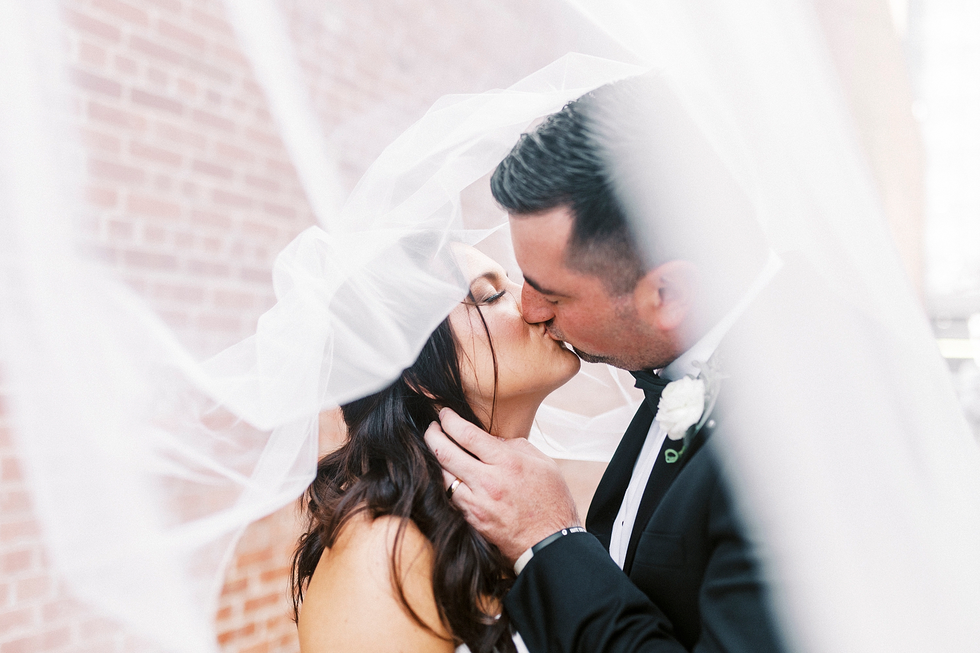 newlyweds kiss under bride's veil at Byron's South End