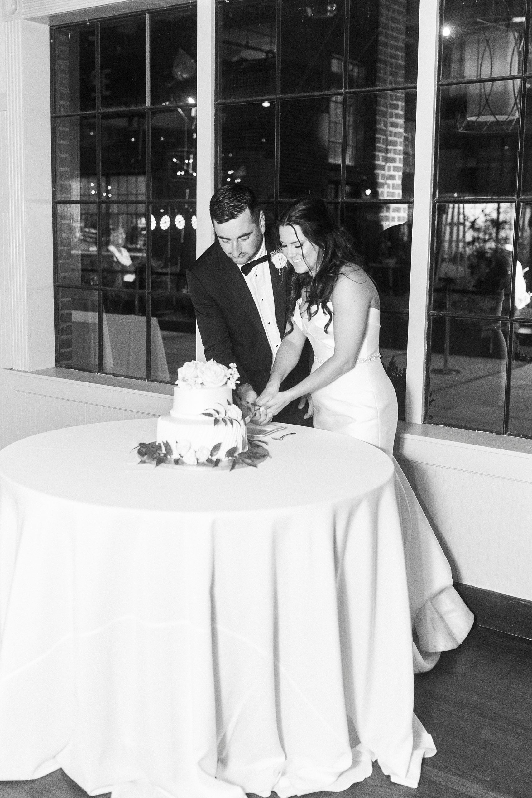 bride and groom cut wedding cake during NC reception