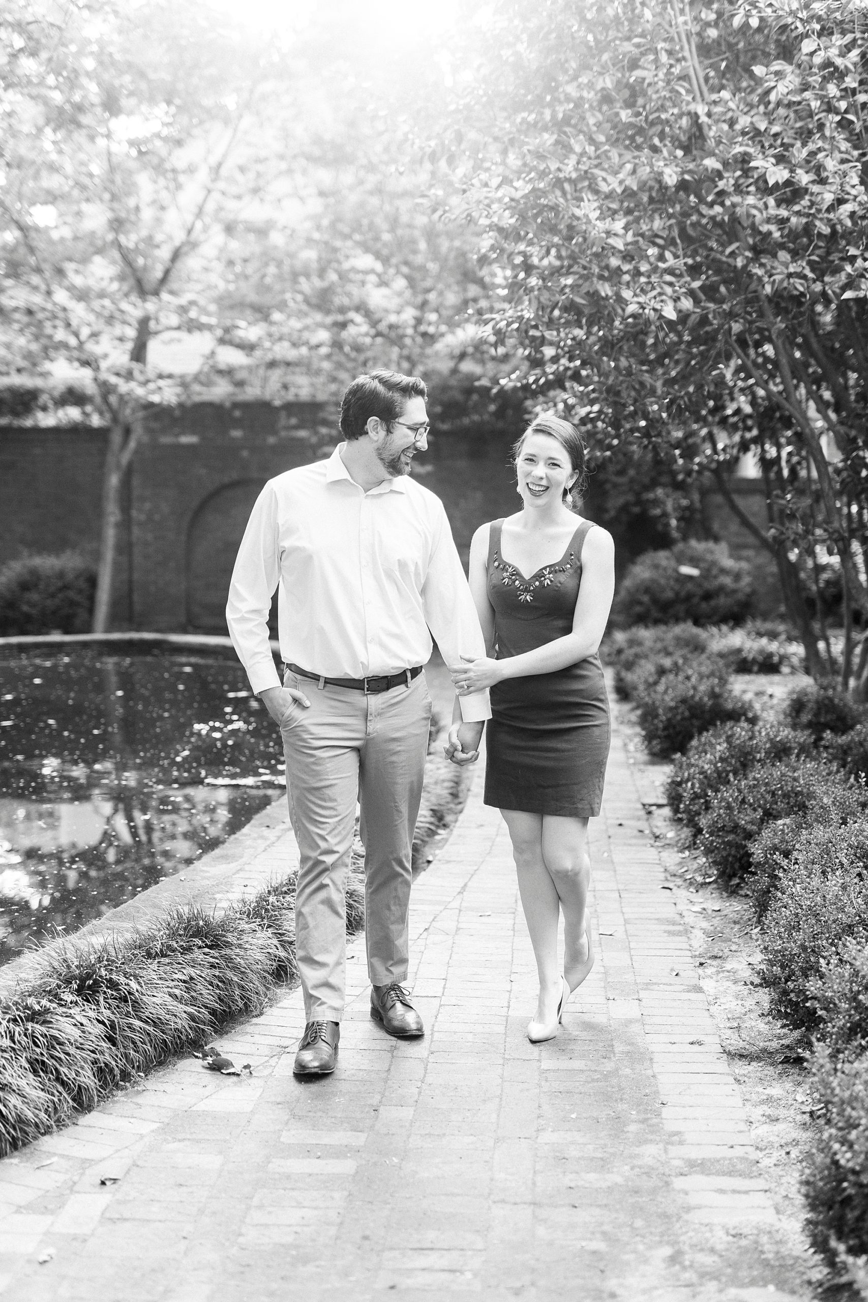 couple holds hands walking through Wing Haven Garden