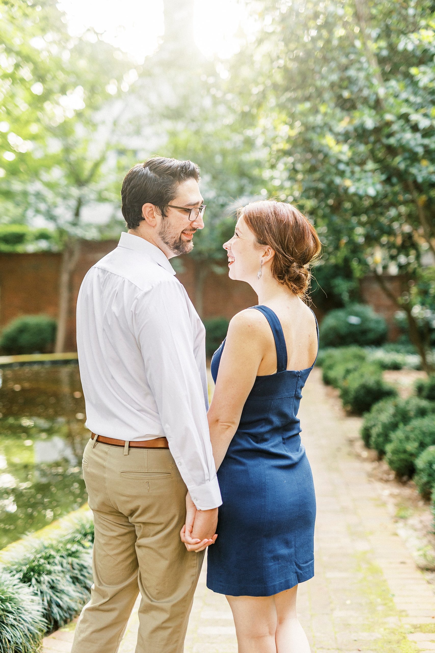 married couple holds hands on brick pathway at Wing Haven Garden