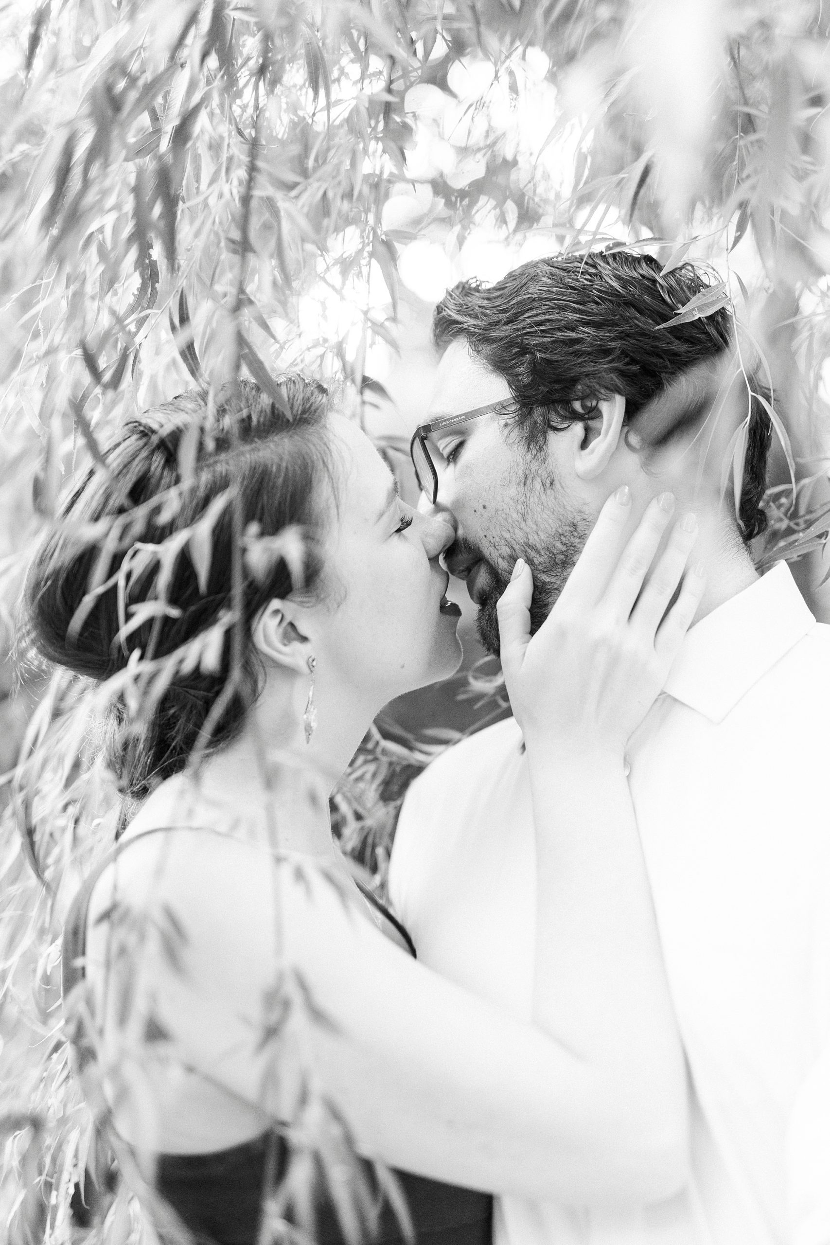 woman kisses husband during anniversary portraits at Wing Haven Garden