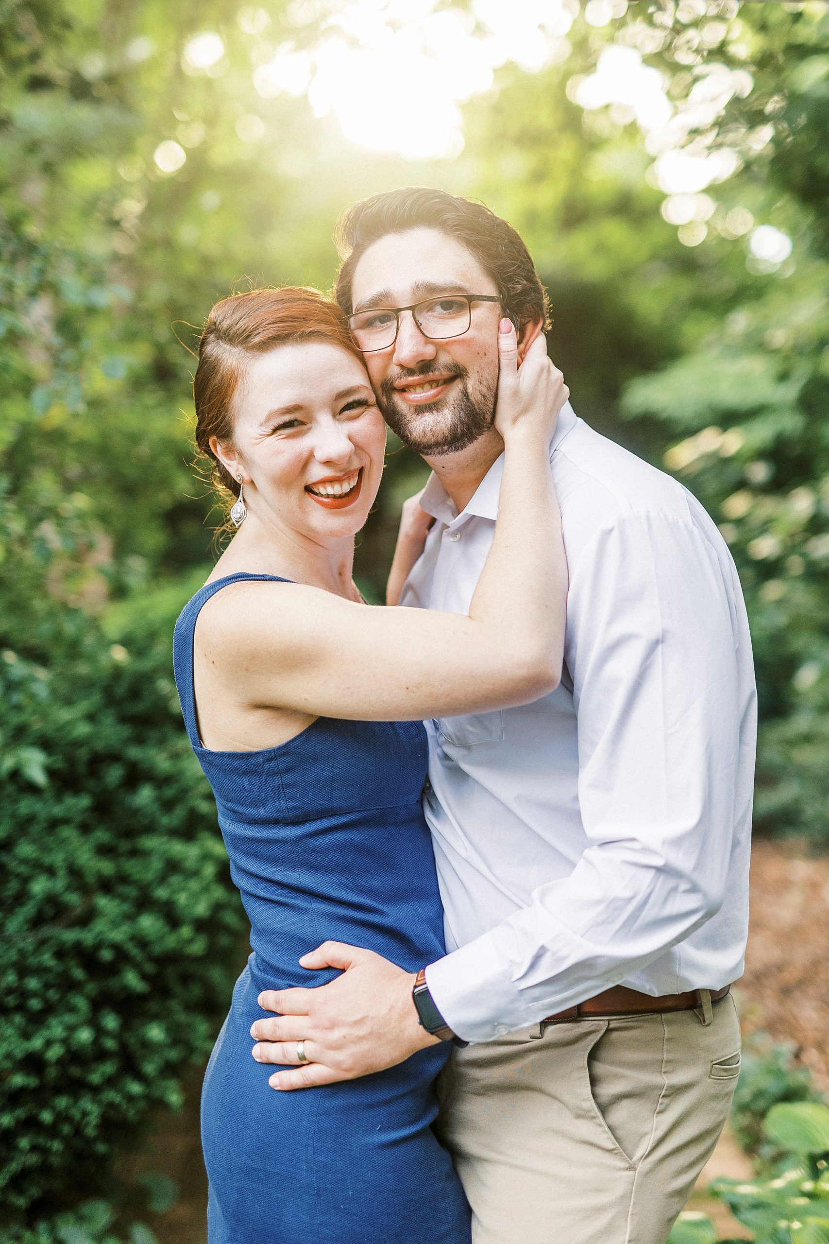 man hugs wife holding her hips standing in Wing Haven Garden
