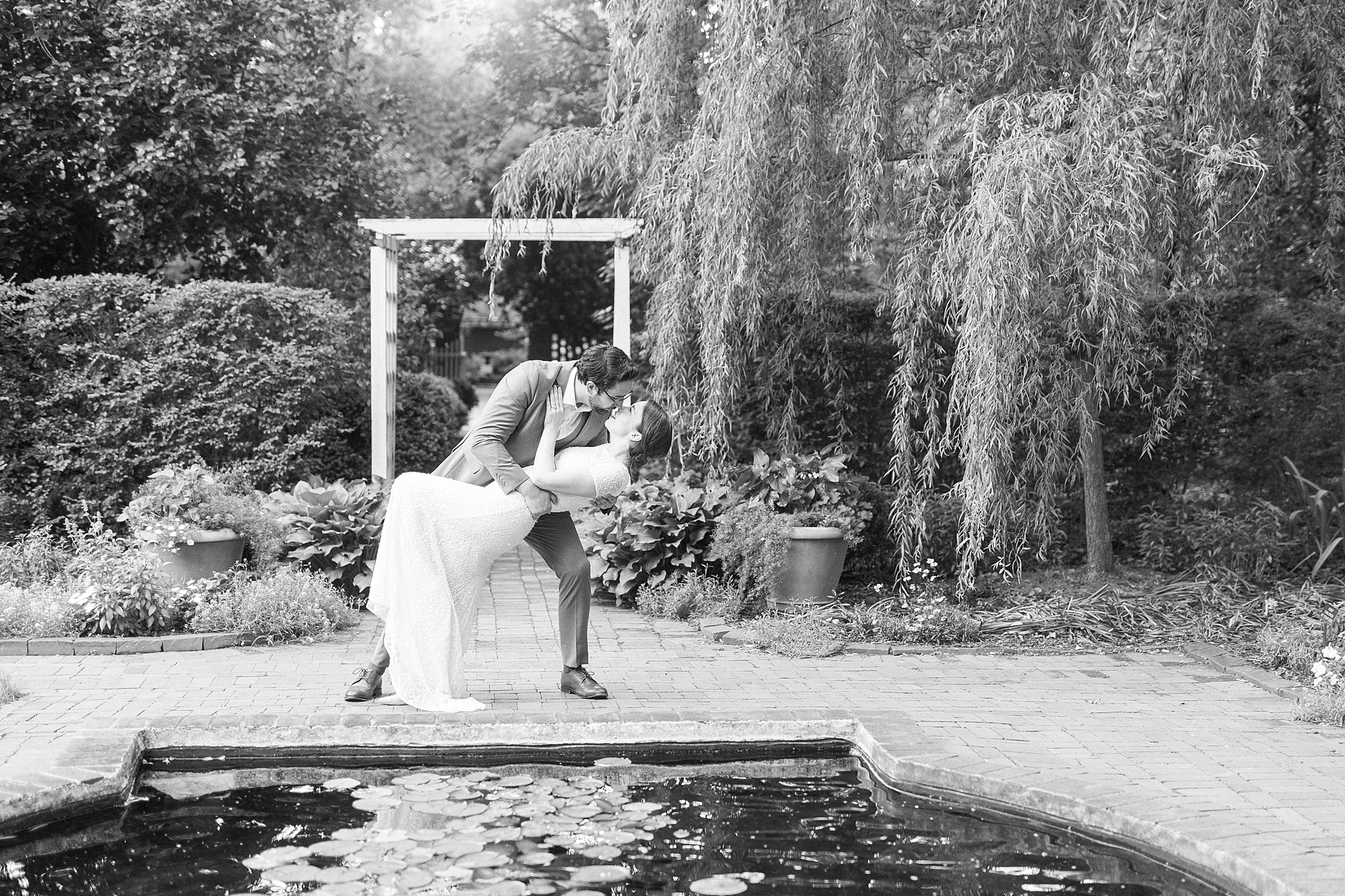 man dips wife backwards in white wedding dress