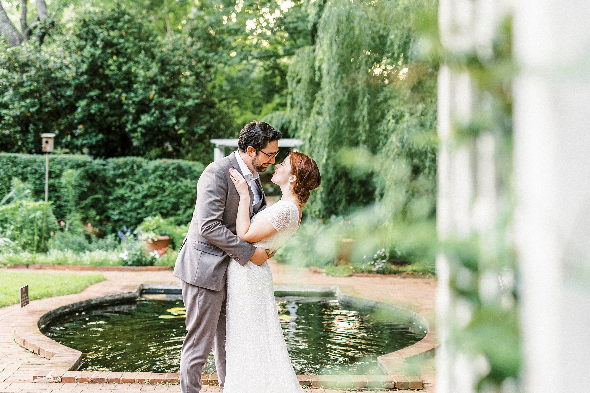 man leans wife back for a kiss in gardens of Wing Haven