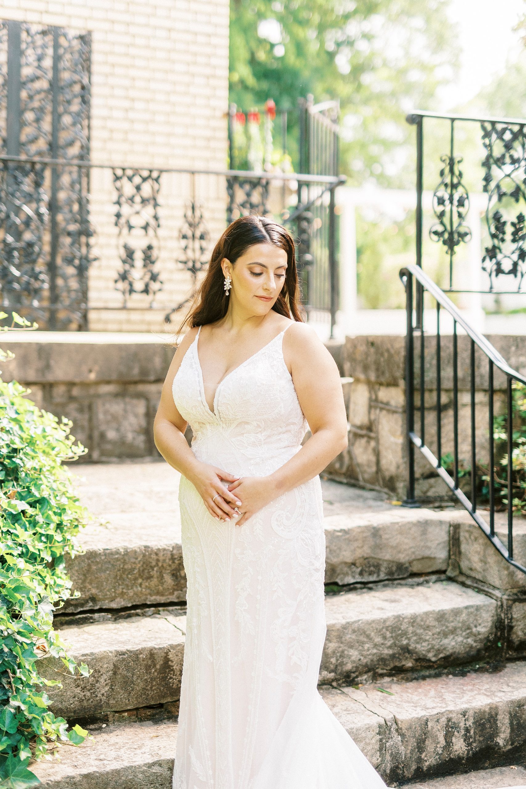 bride stands with hands on hip outside staircase at Separk Mansion